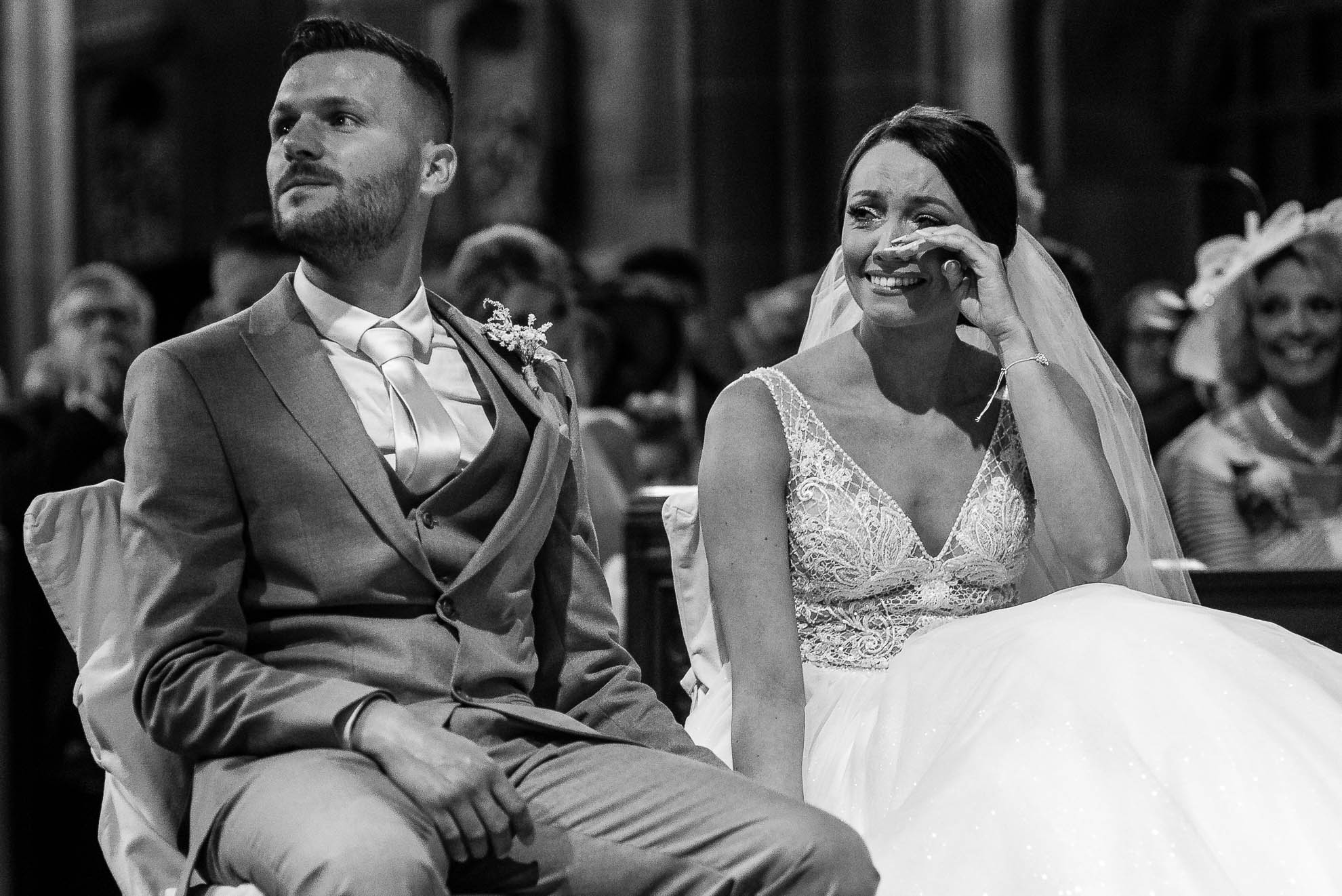 Bride wipes away a tear during wedding