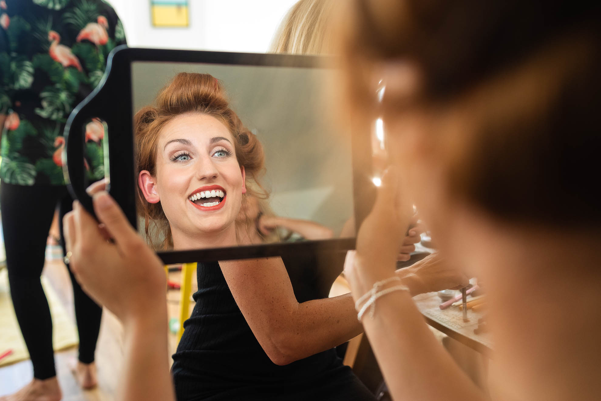 Bride smiles as she looks in mirror