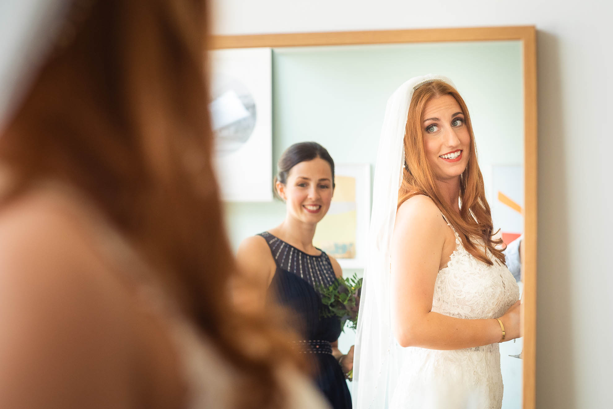 Bride admires her dress in the mirror