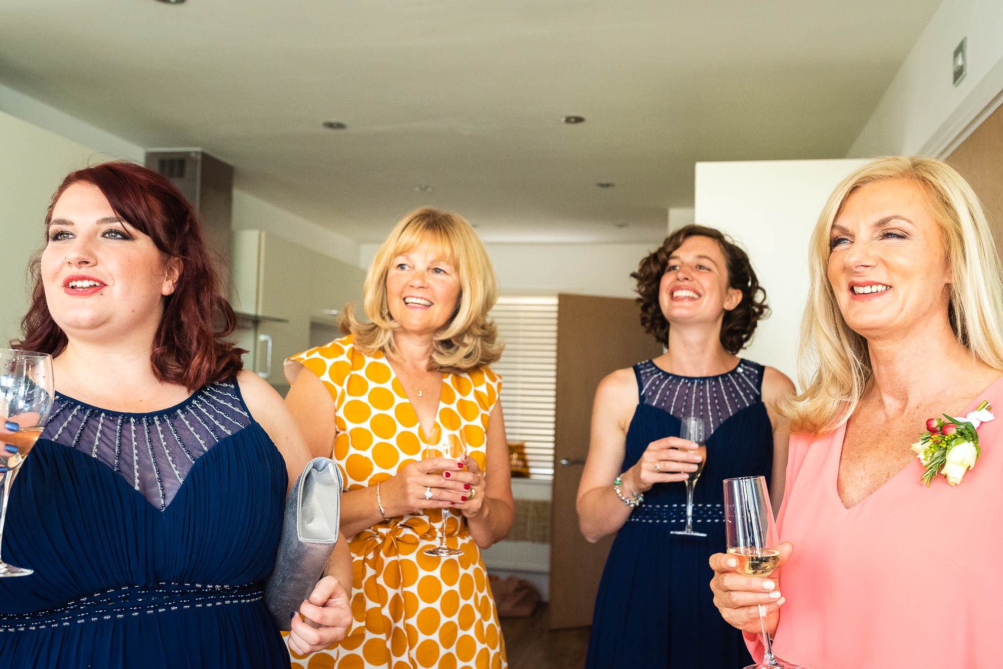 bridesmaids and mum look at the bride in approval