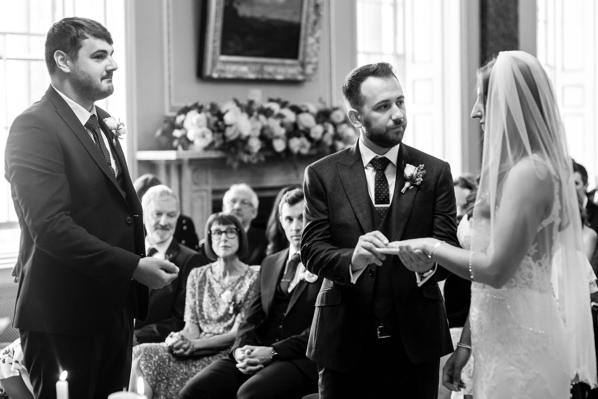 Groom places ring on brides finger