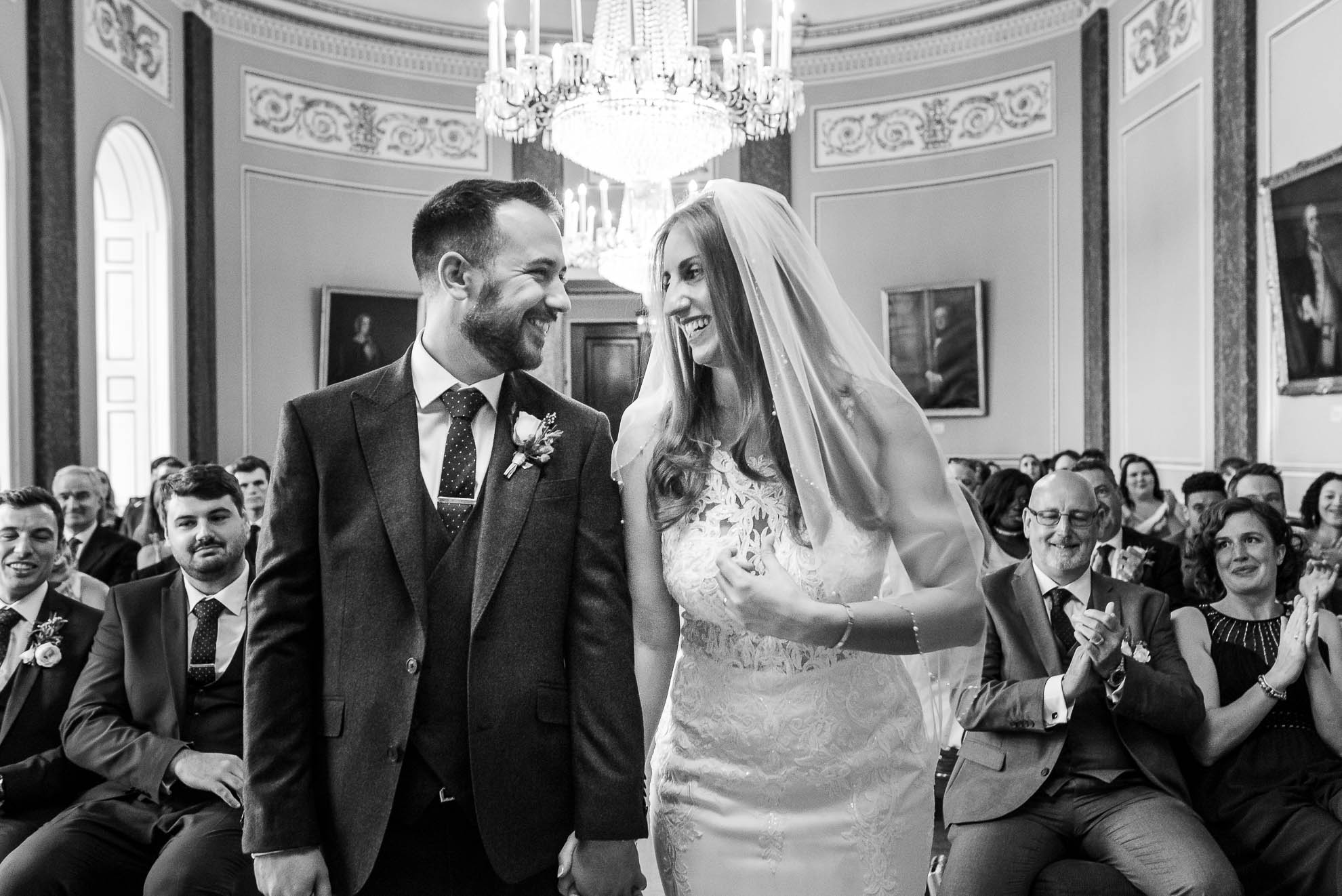 Bride and Groom smile at each other 