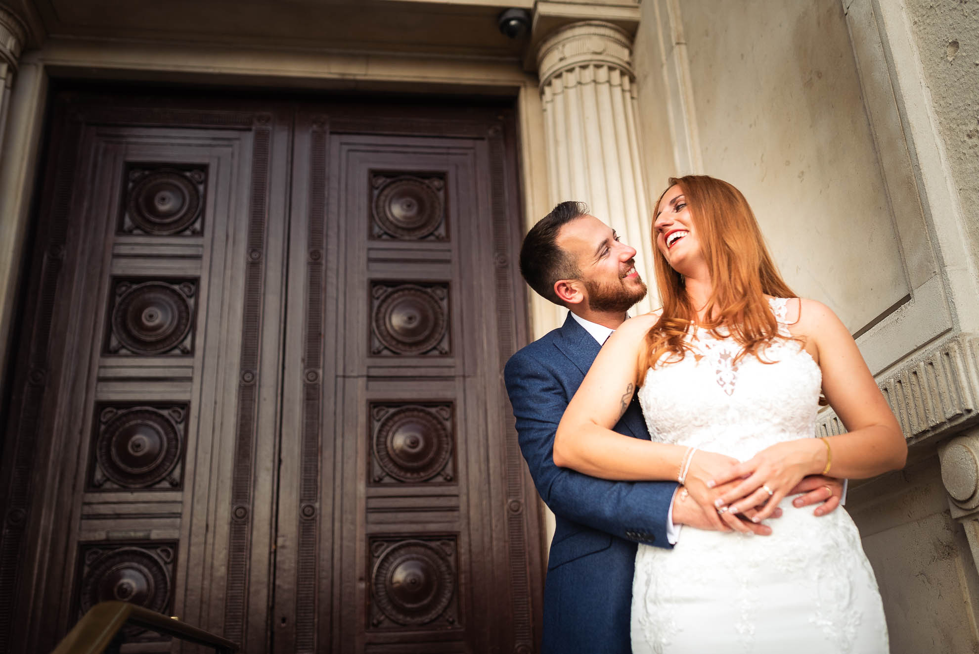 Bride and groom hug each other and are laughing