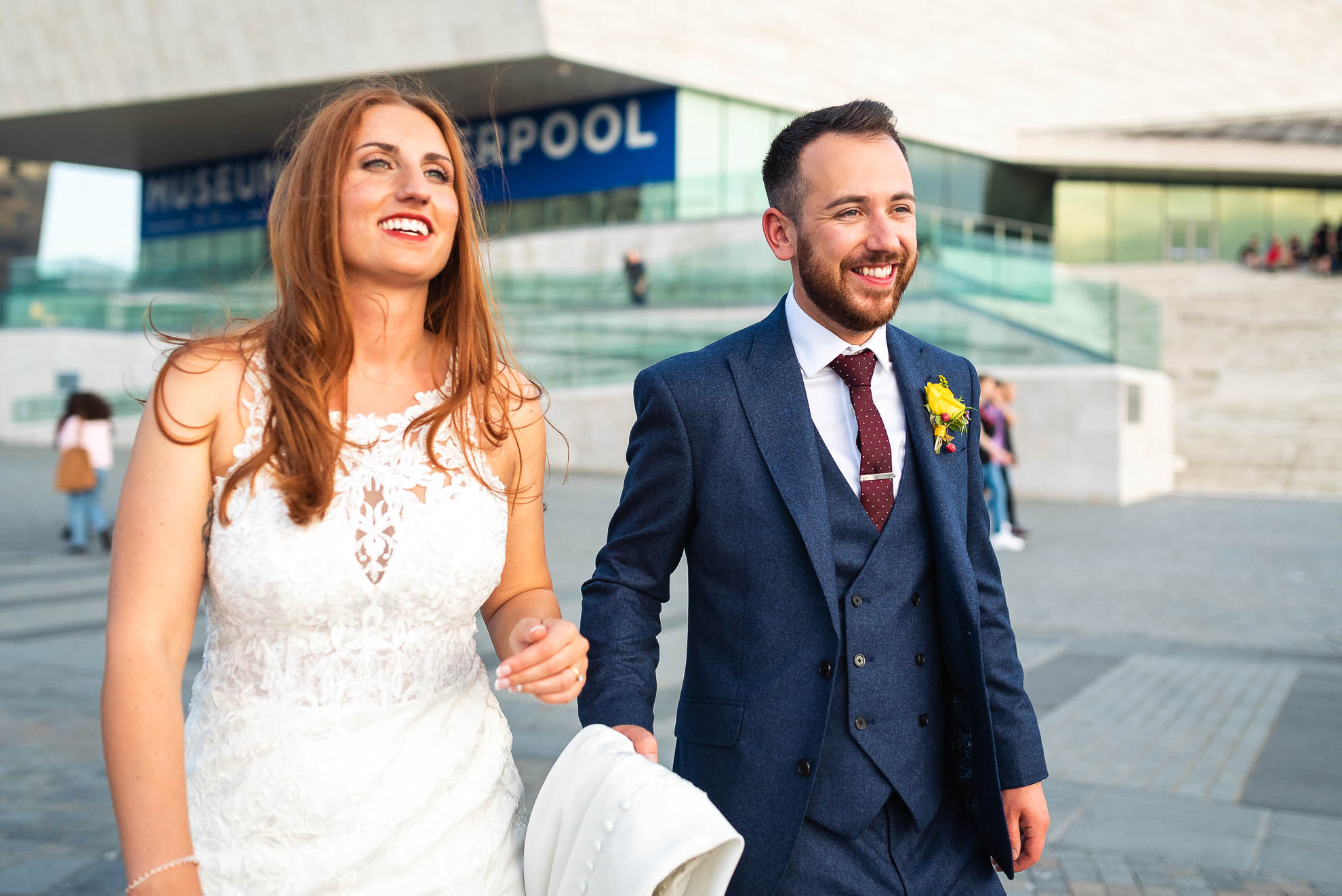Bride and groom walk towards the waterfront