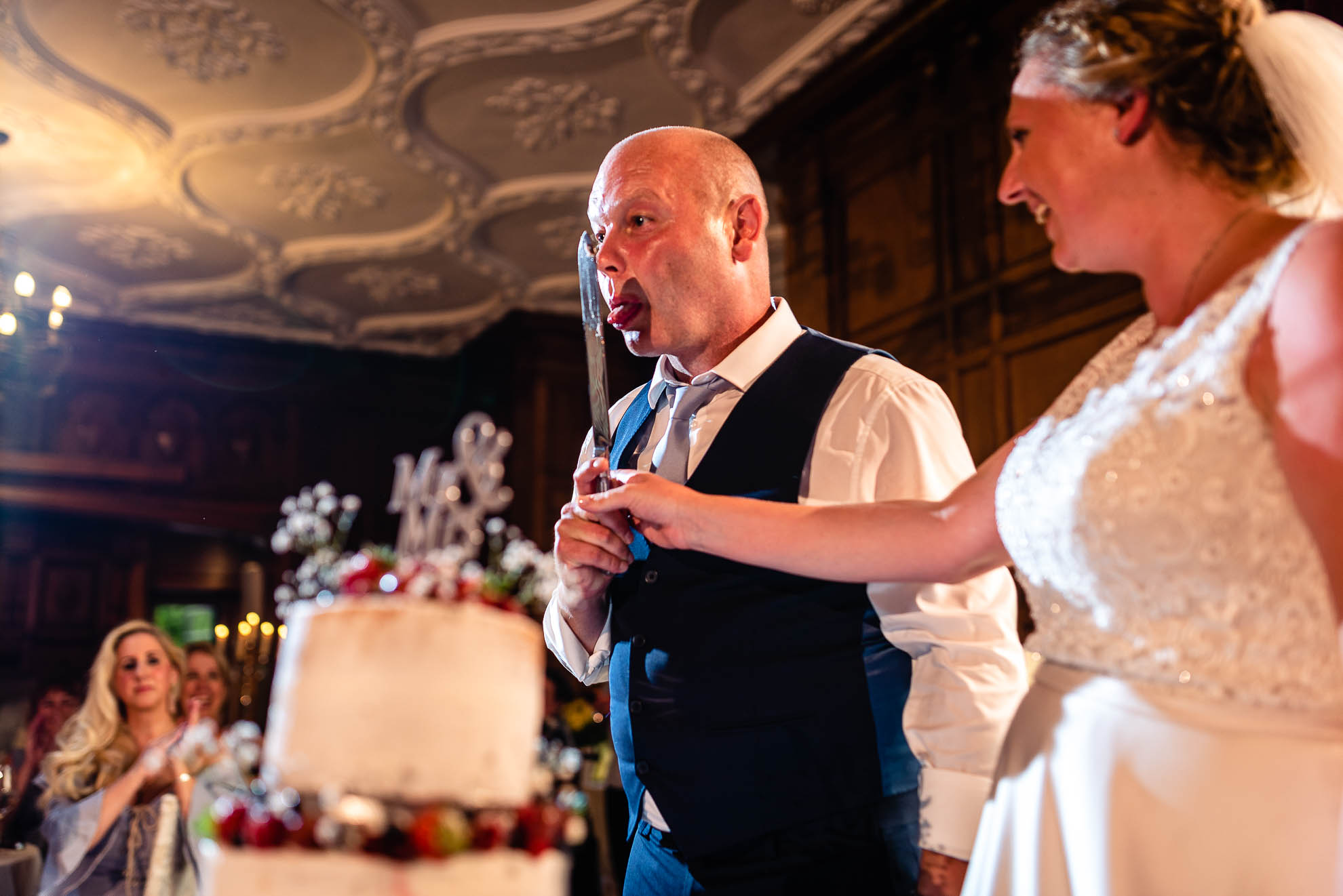 Groom licks knife after cutting the cake