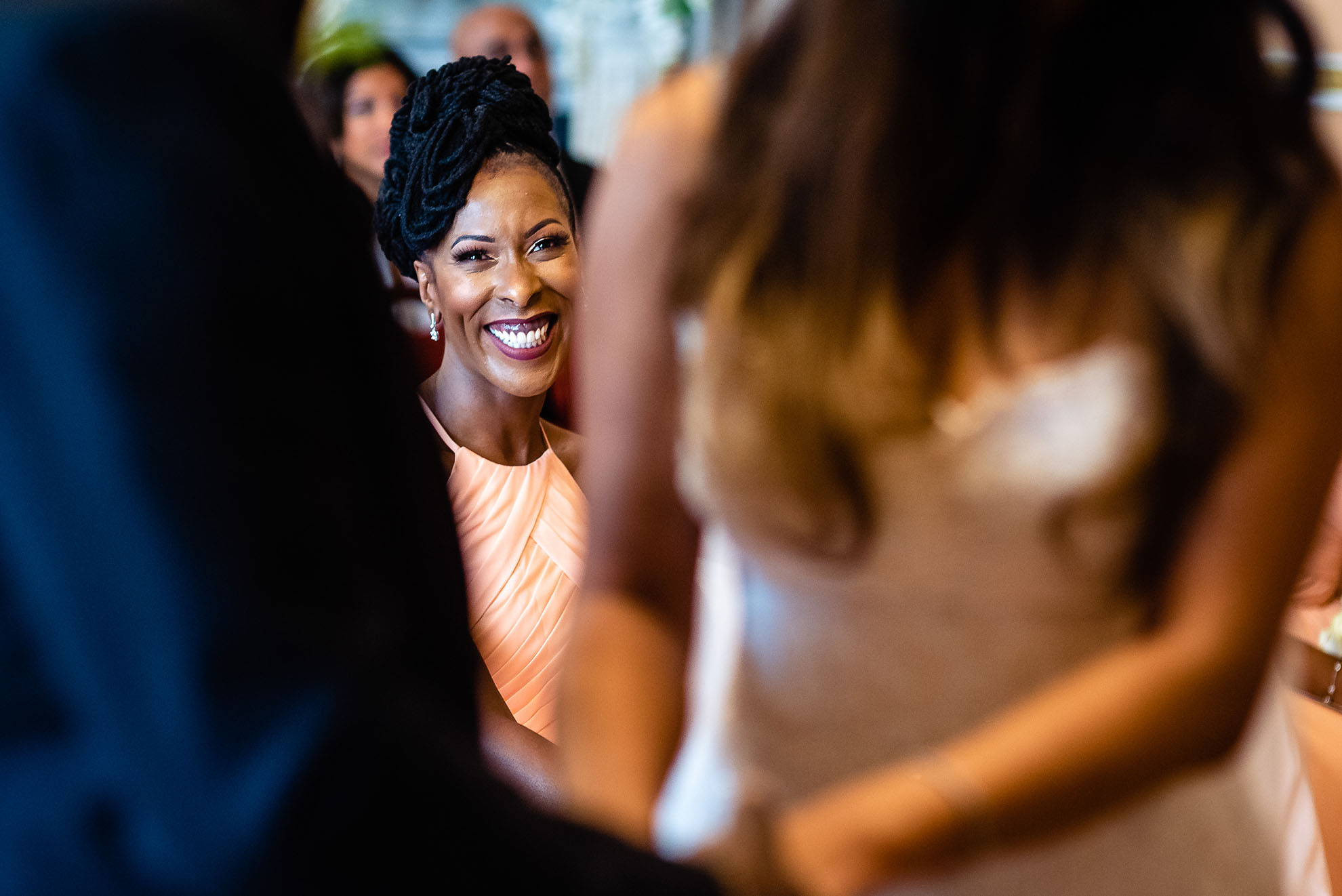 Bridesmaid looks on smiling during the exchange of vows