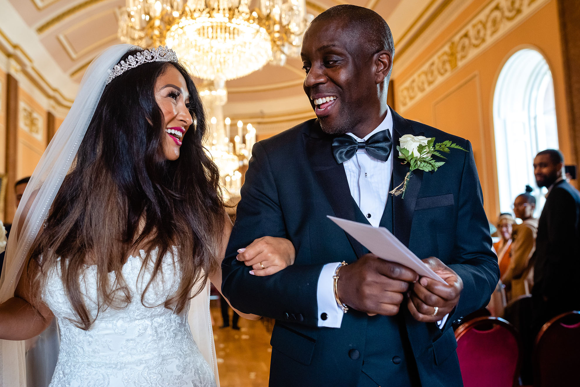 The newlyweds smile at each other as they walk back down the aisle