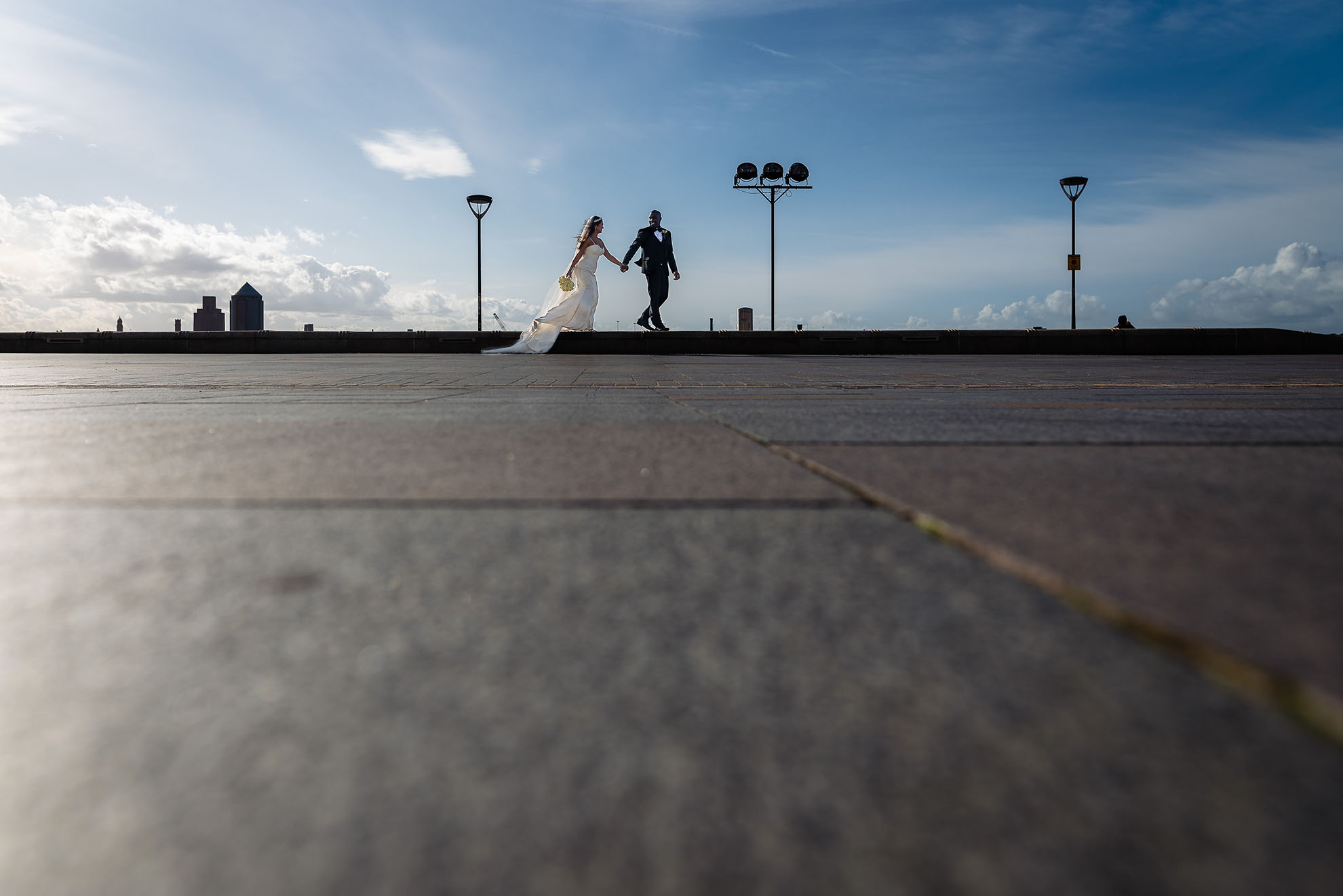 Bride and groom walking together along waterfront