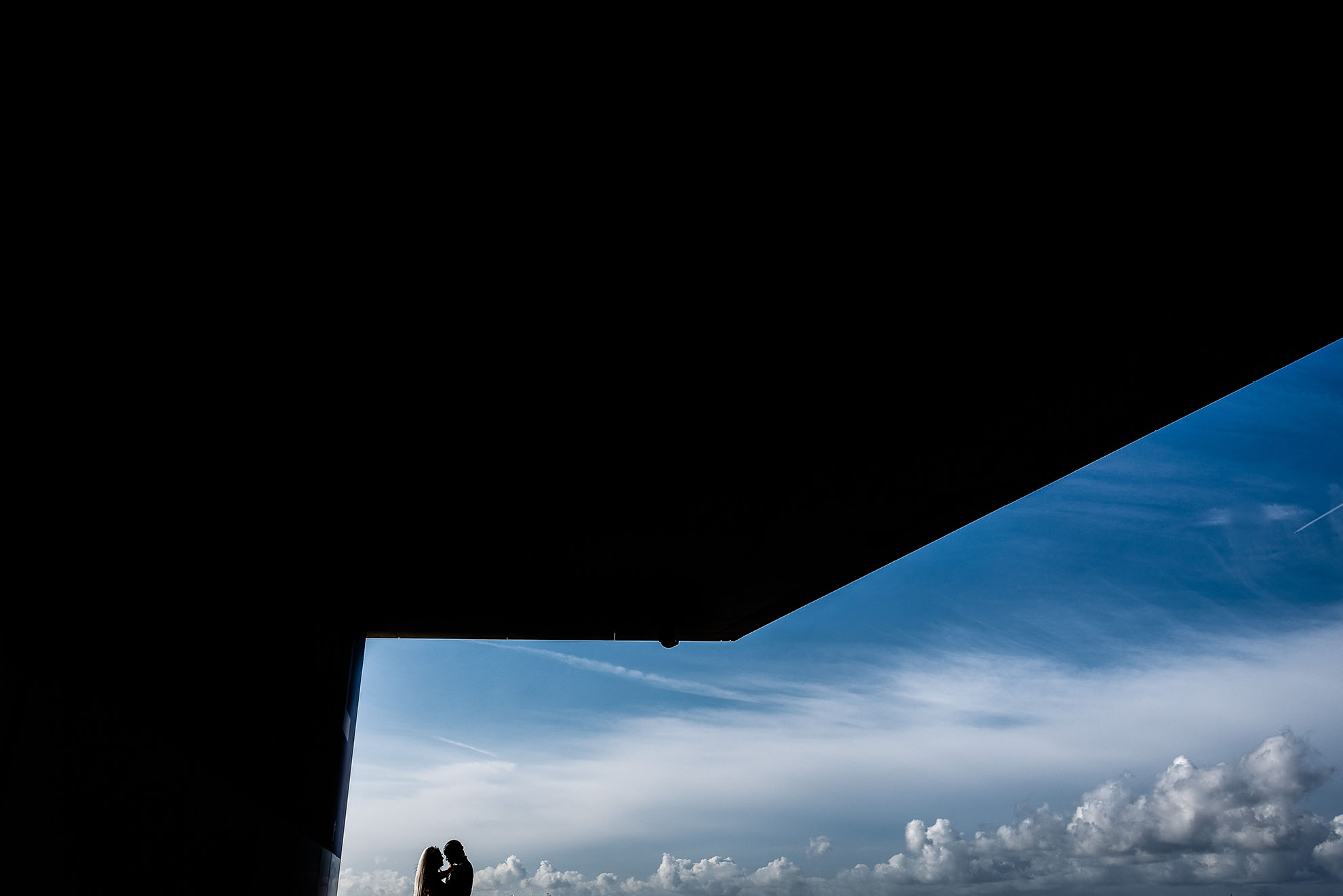 Bride and groom silhouette with sky behind