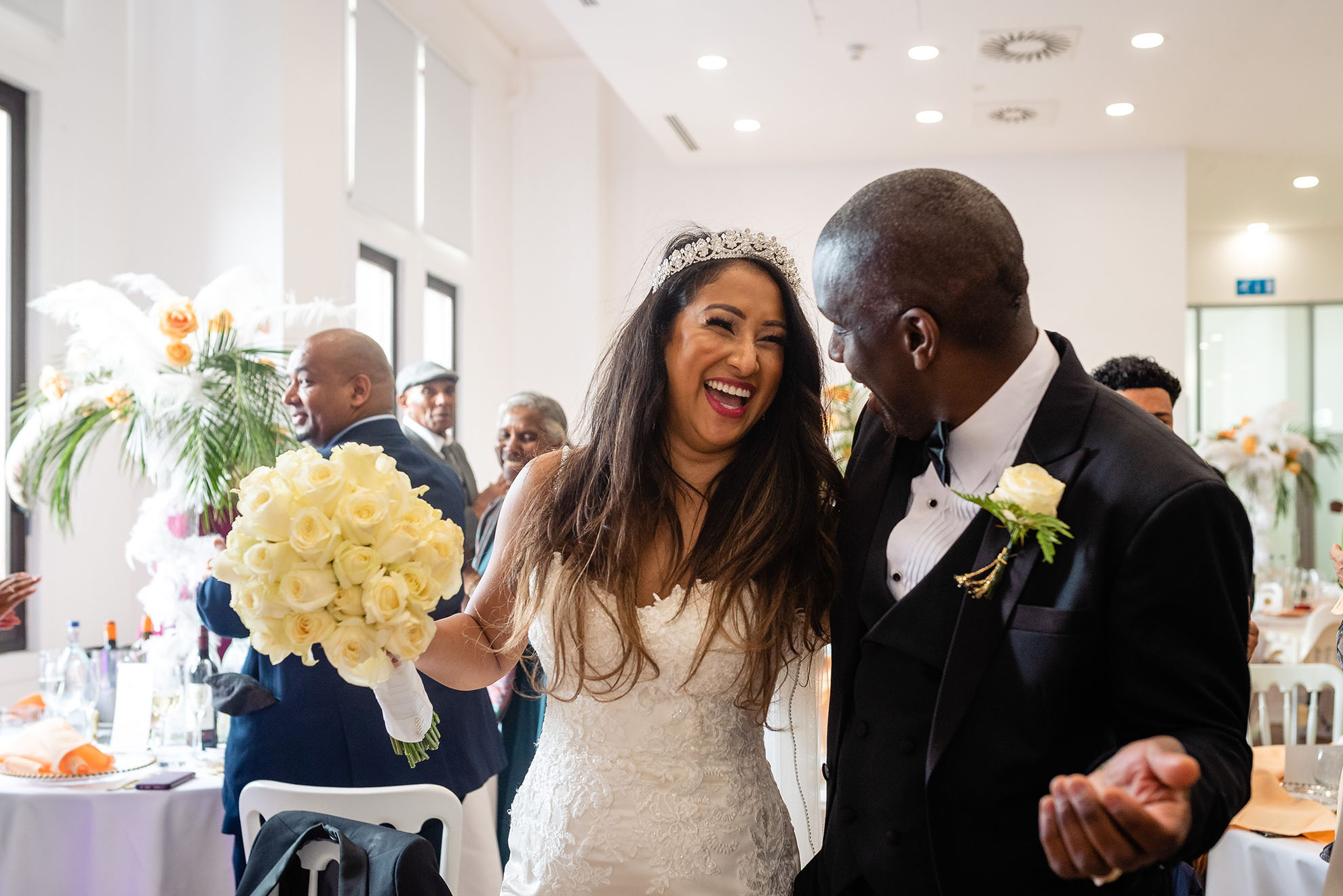 Bride and groom share a joke as they enter the wedding breakfast