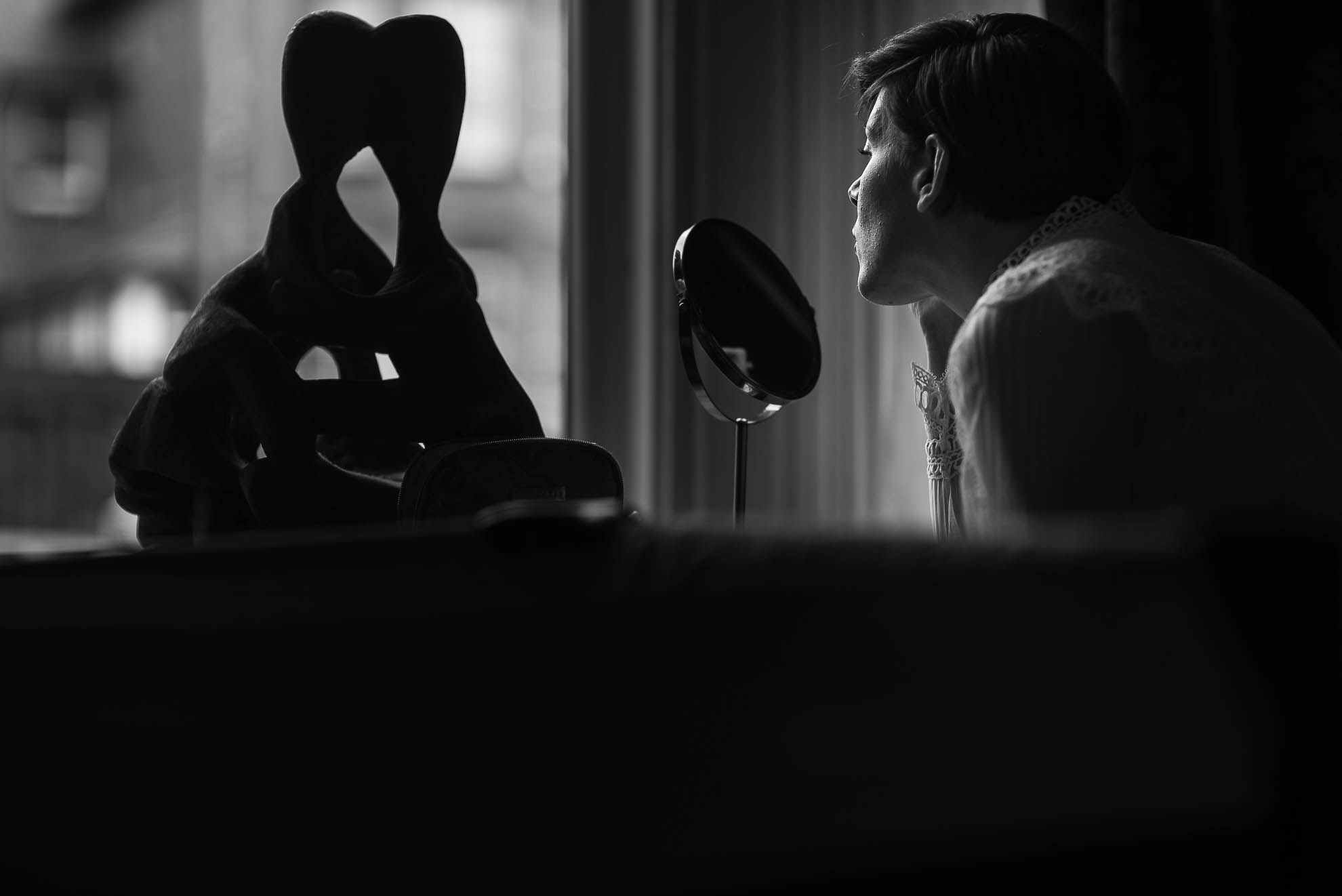 Bride applies make up during bridal preparations