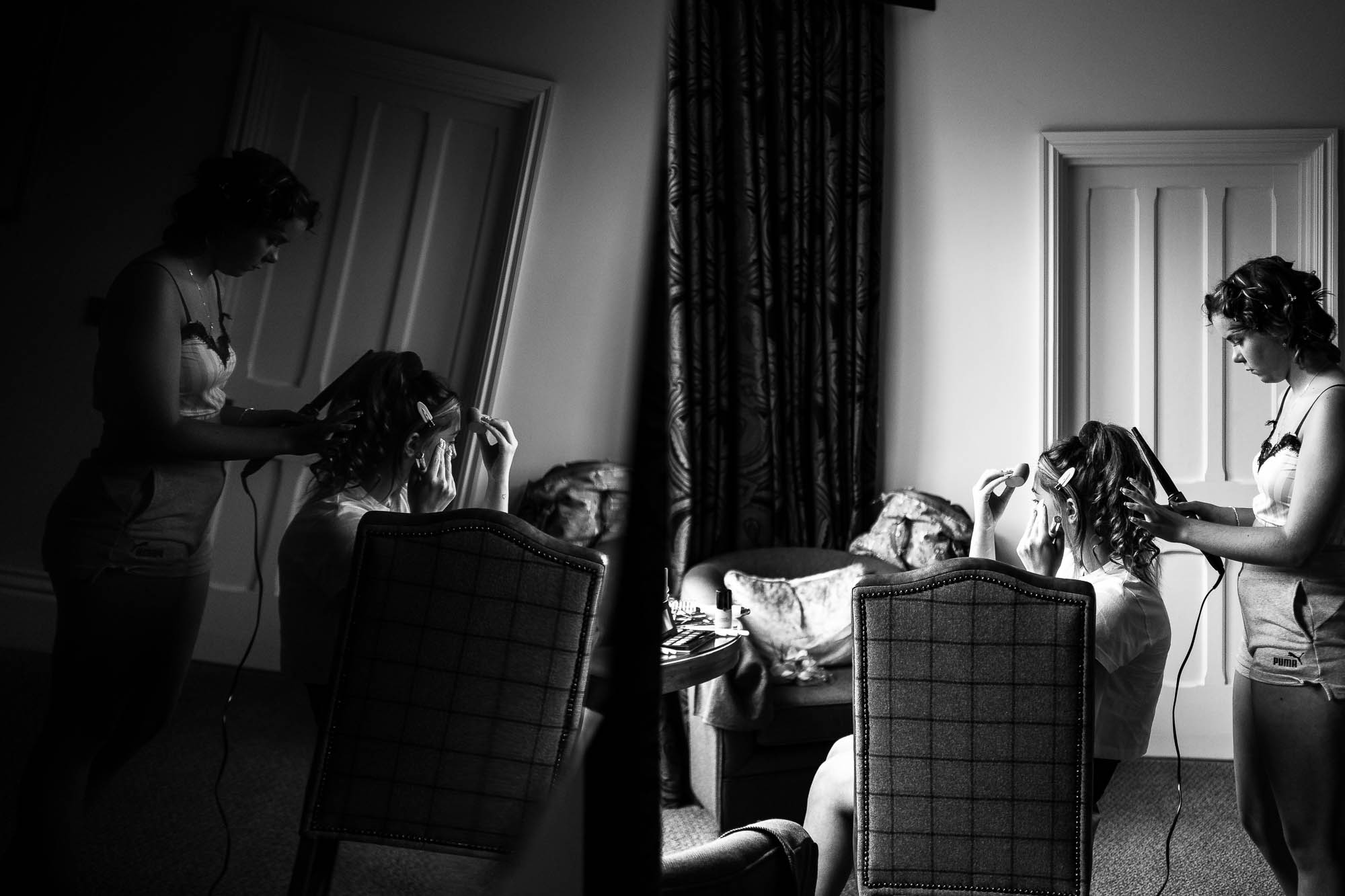 Bridesmaid helps bride style her hair