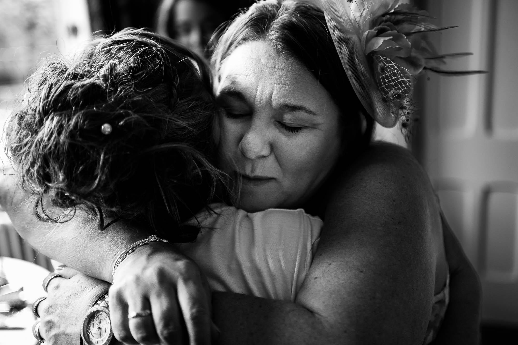 Mother of bride hugs bride