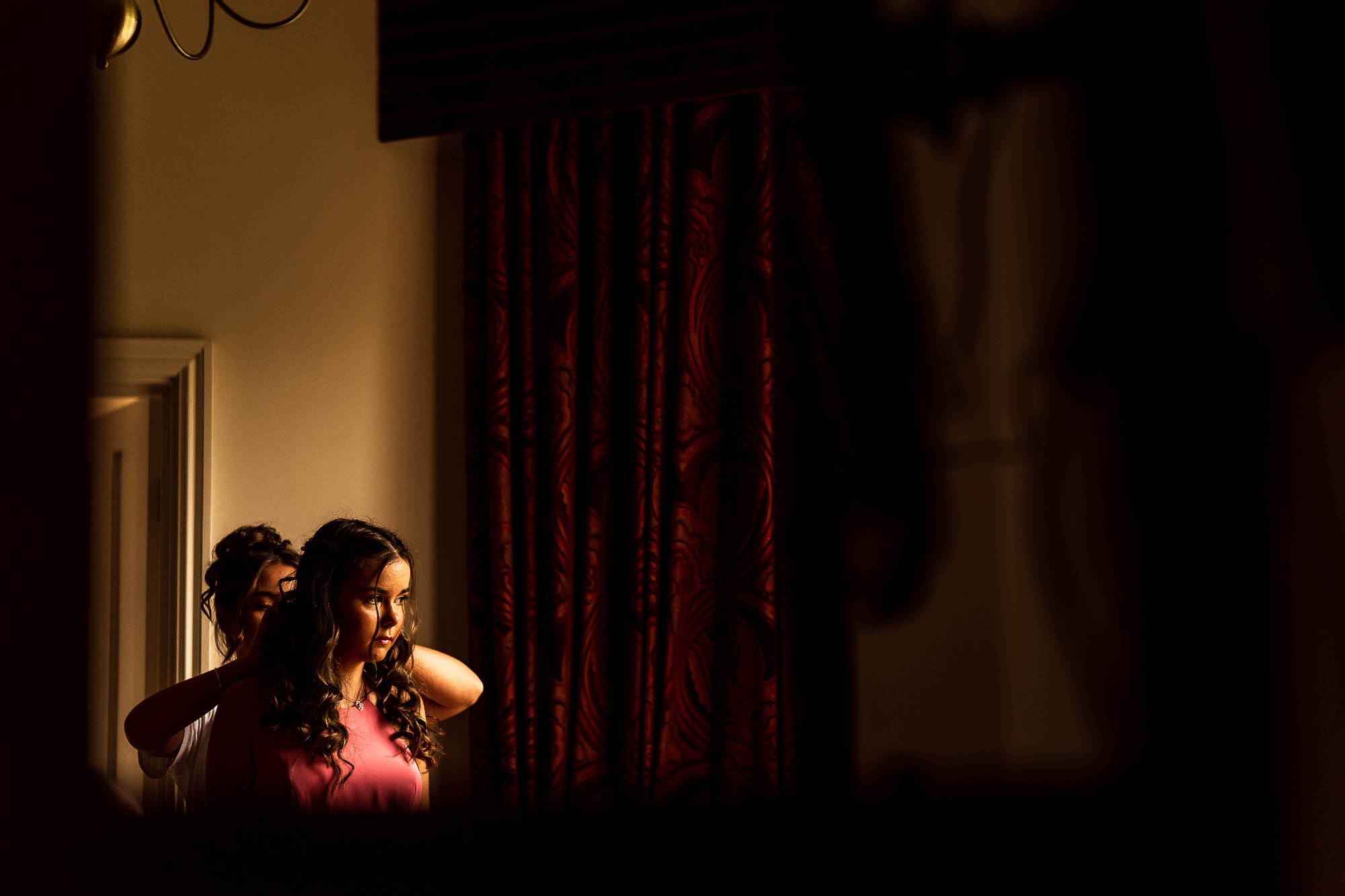 Bride helps bridesmaid into her dress