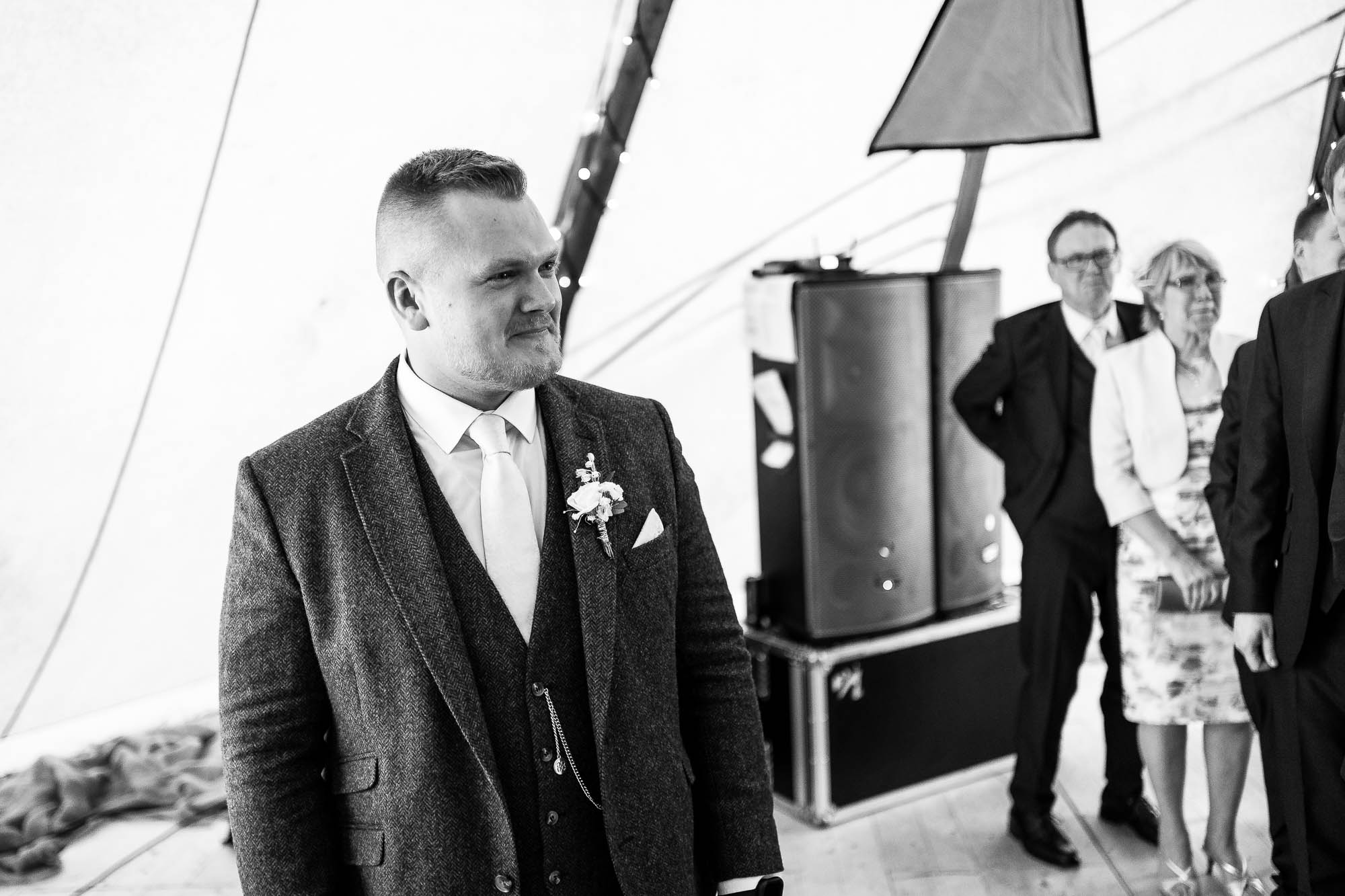 Groom watches his bride walk up the aisle