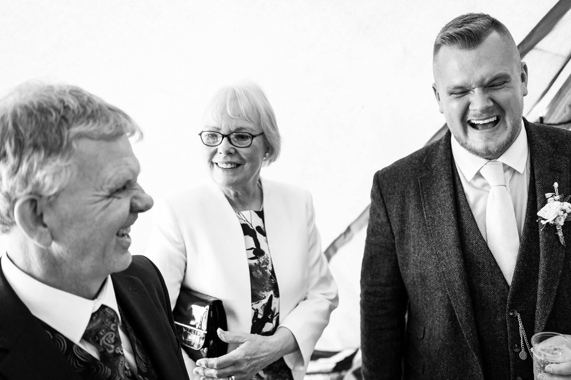 Groom shares a joke with wedding guests