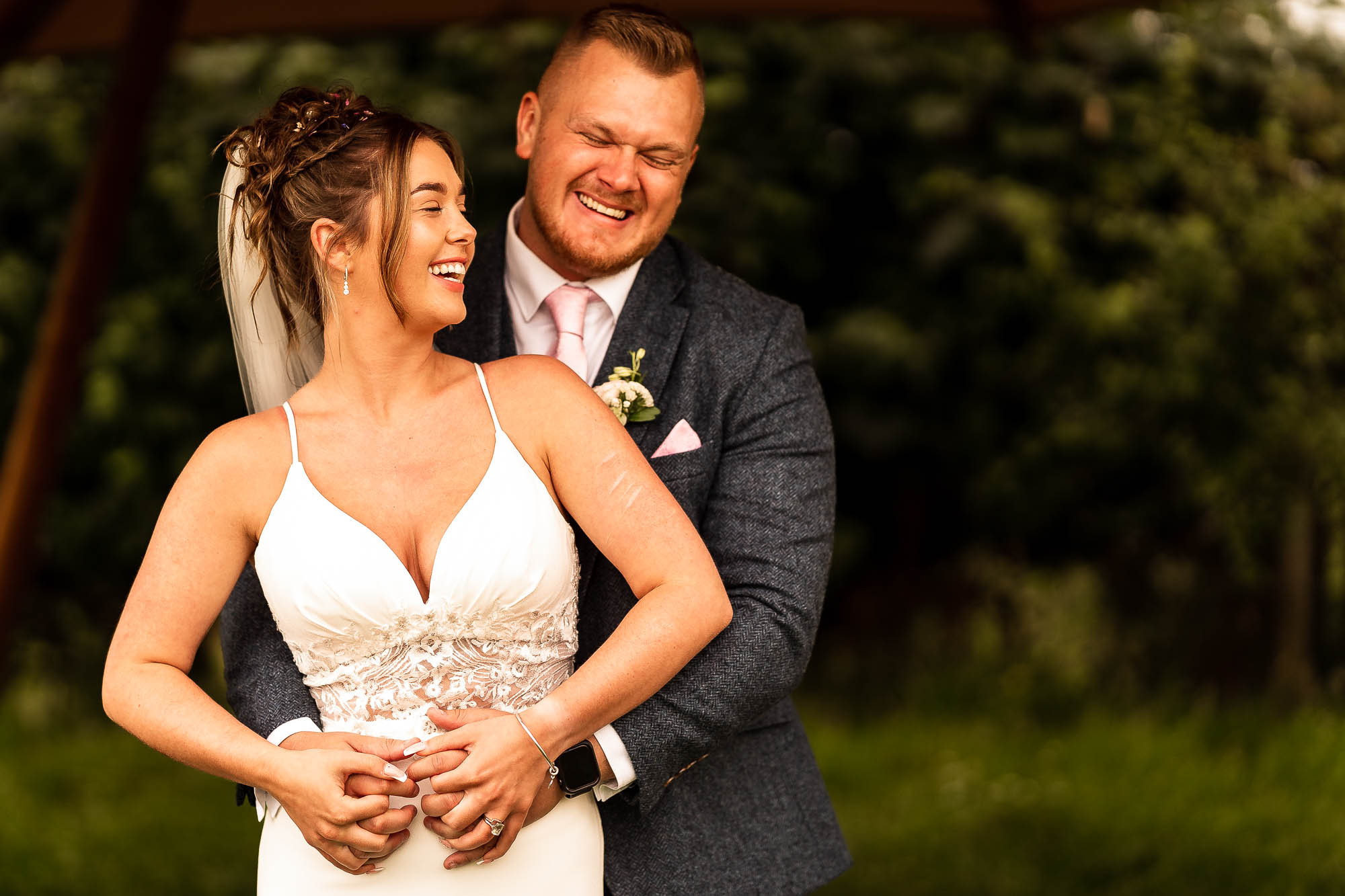 Bride and groom laugh during portrait photographs