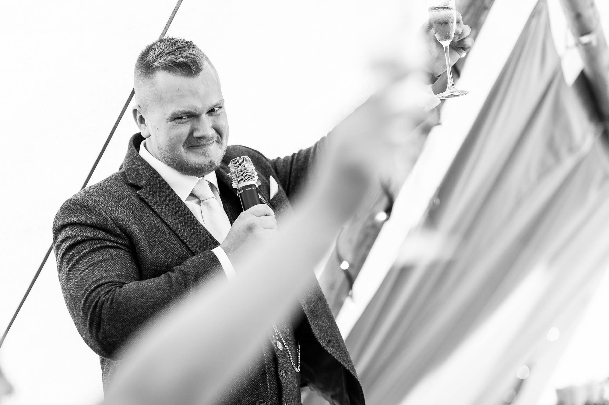 groom raises a glass to the bride