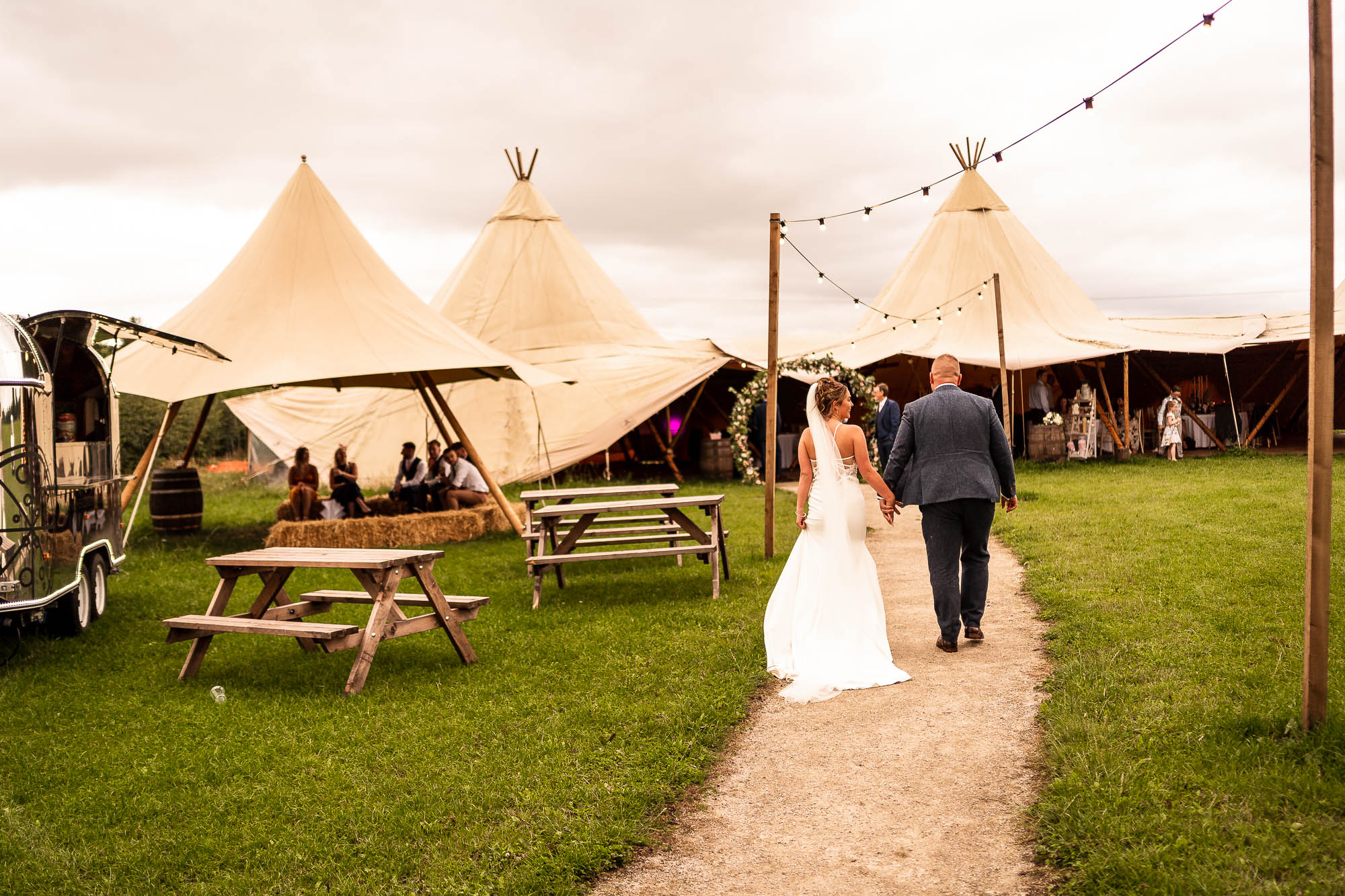 Bride and groom walsk back towards Betty's Tipi Inglenook farm
