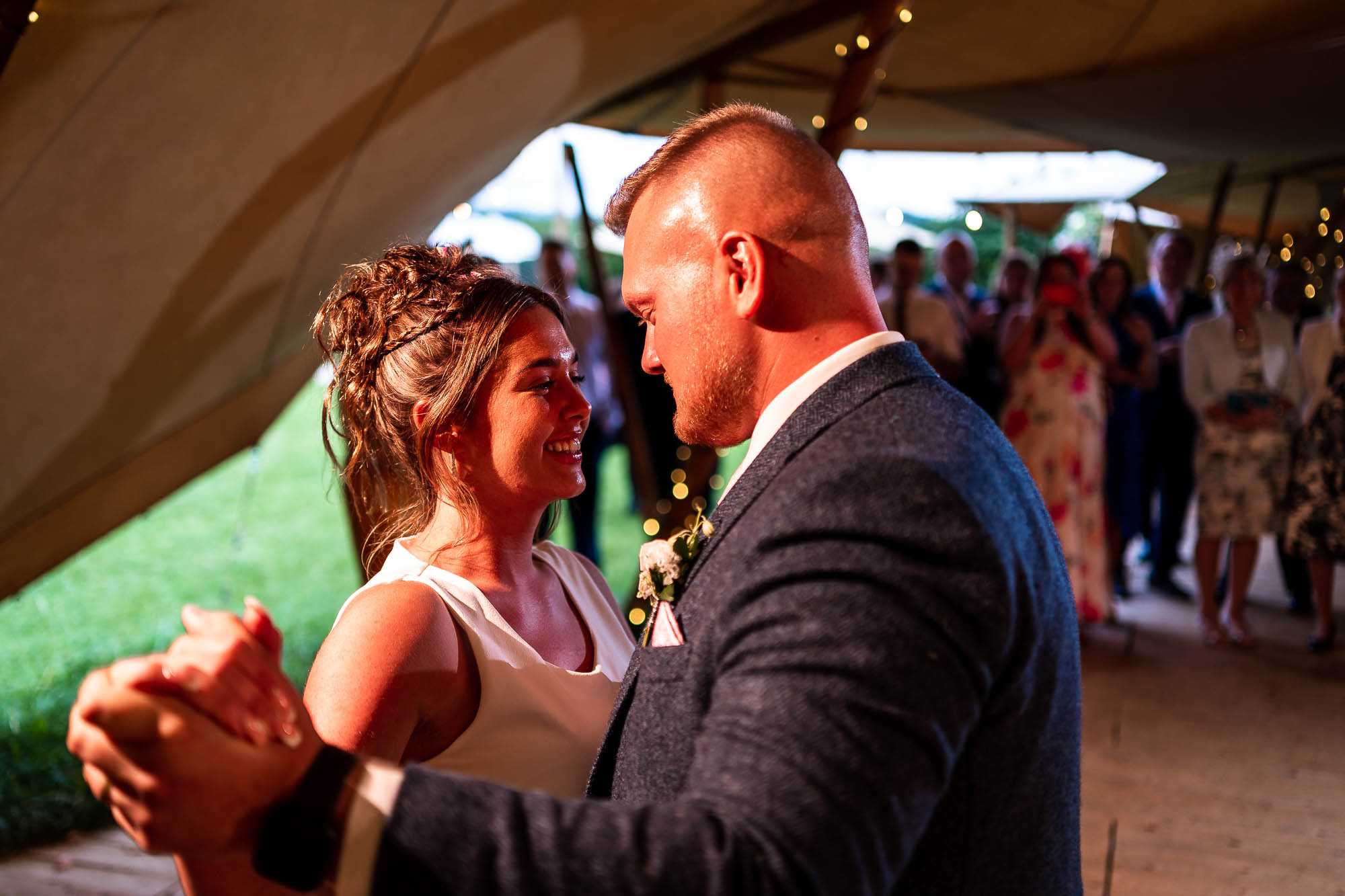 Bride and groom smile together on th dance floor