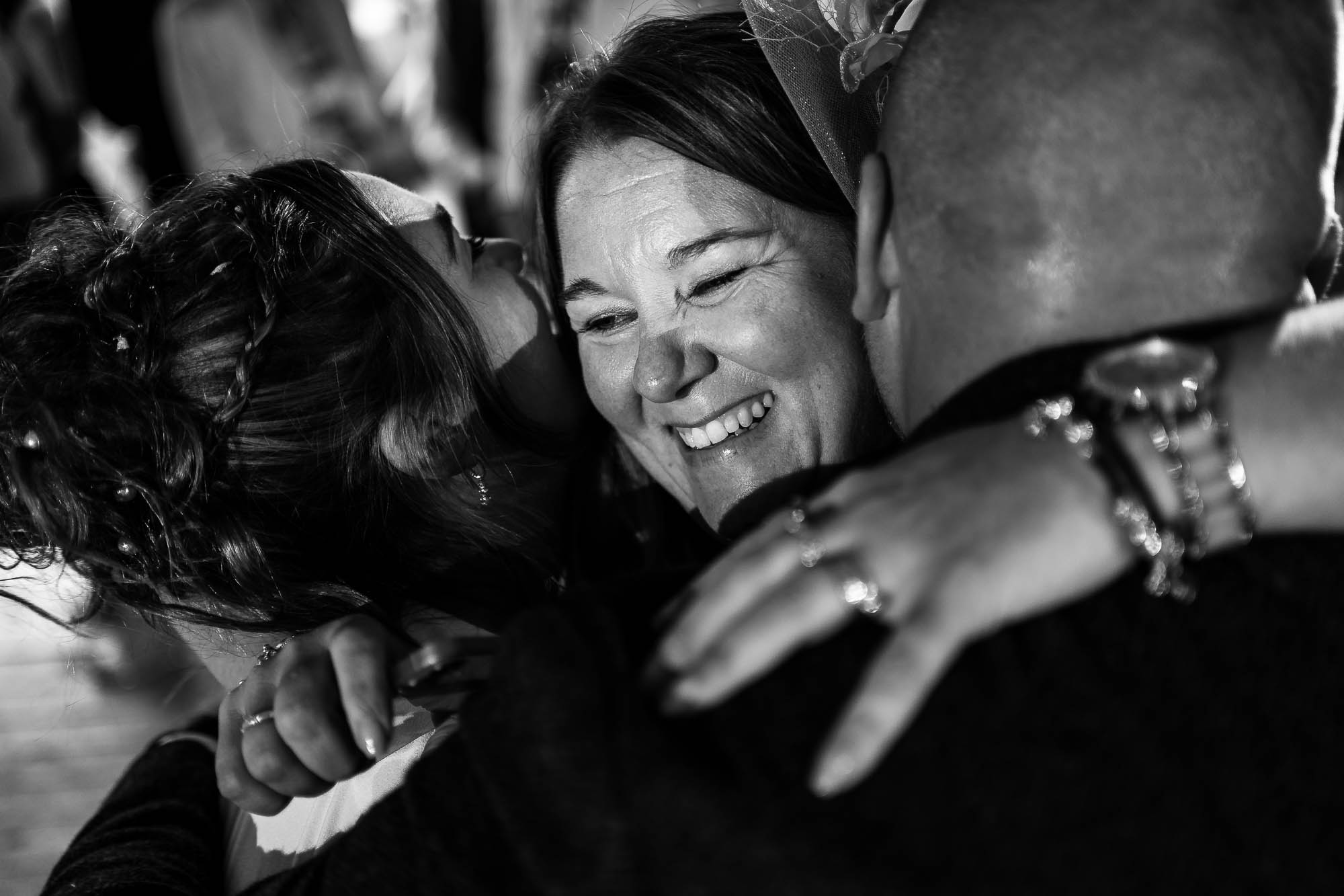 Mother of the bride hugs the happy couple