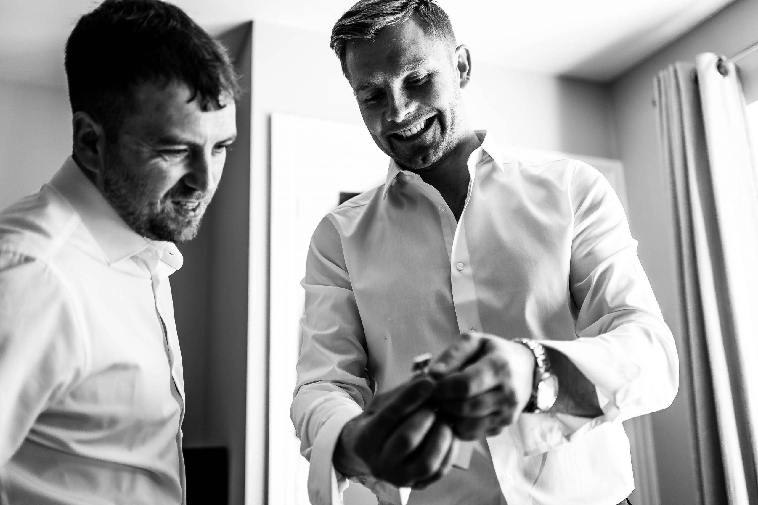 Groom shows gift cufflinks from bride to best man