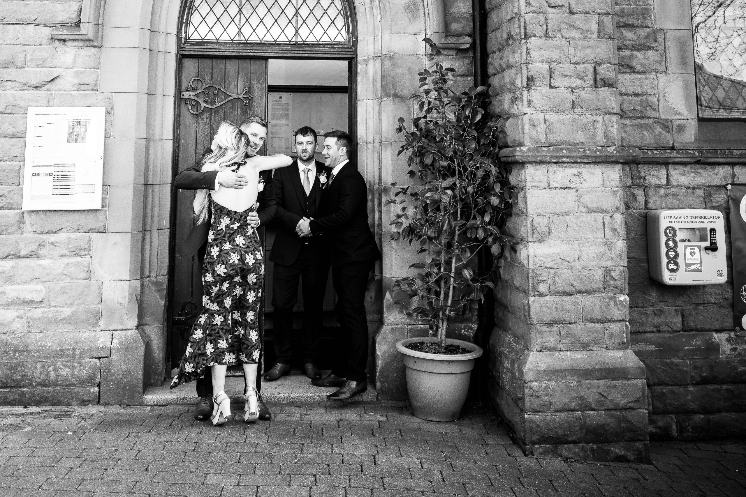 Groom hugs wedding guest