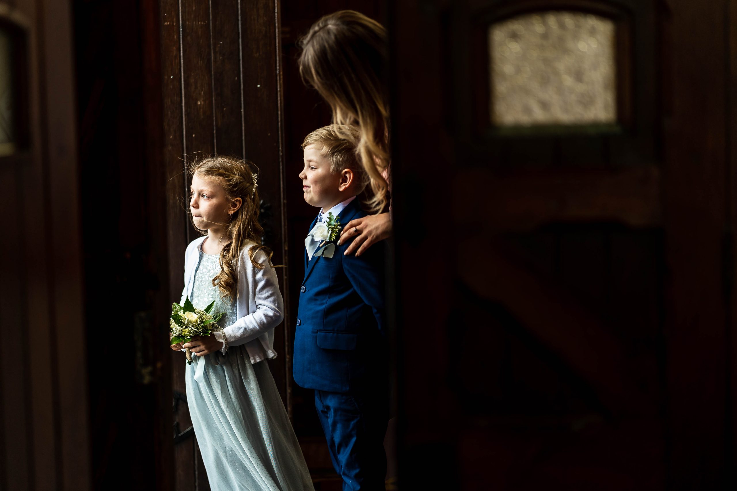 Page boy and flower girl wait for bride to arrive at church