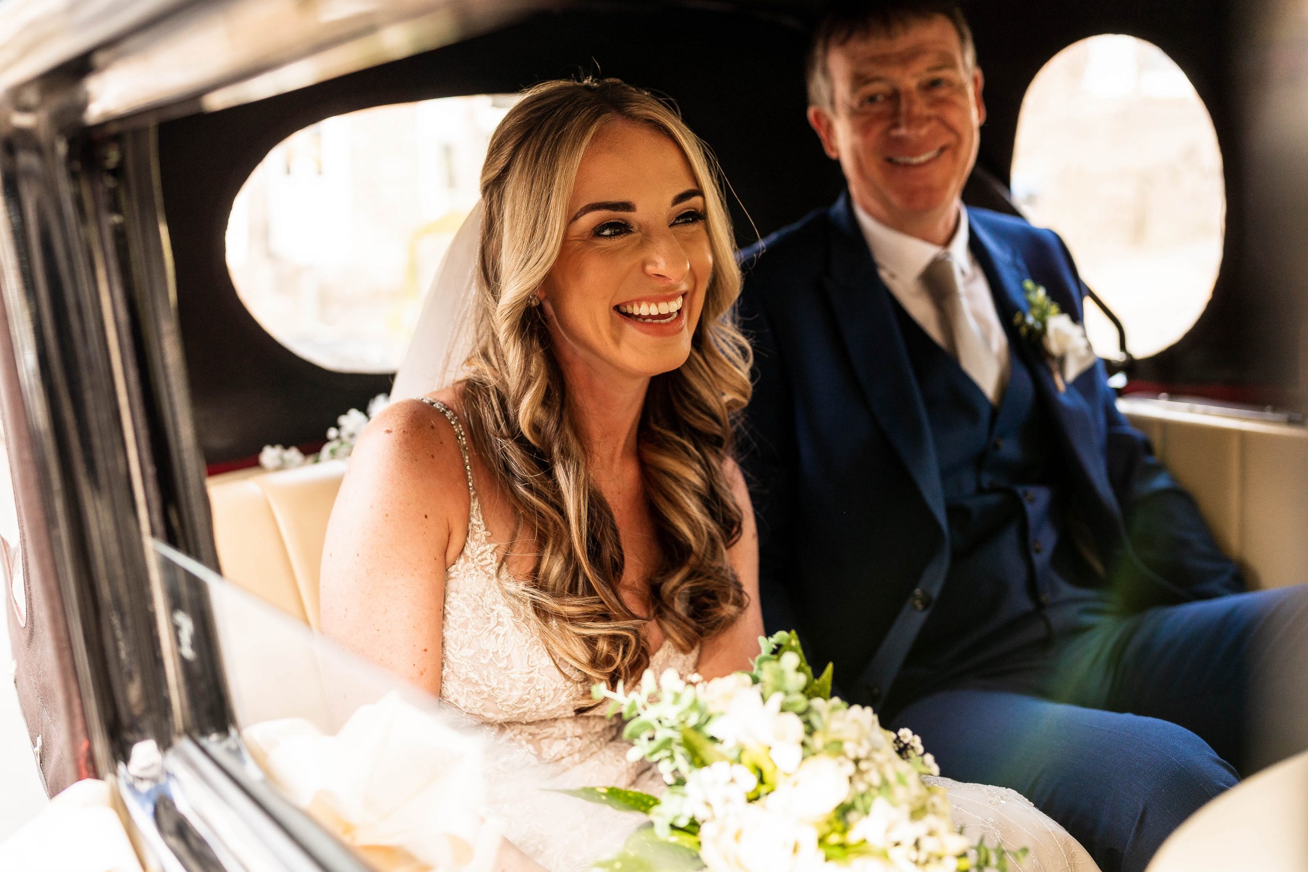 Bride laughs as she arrives in the wedding car
