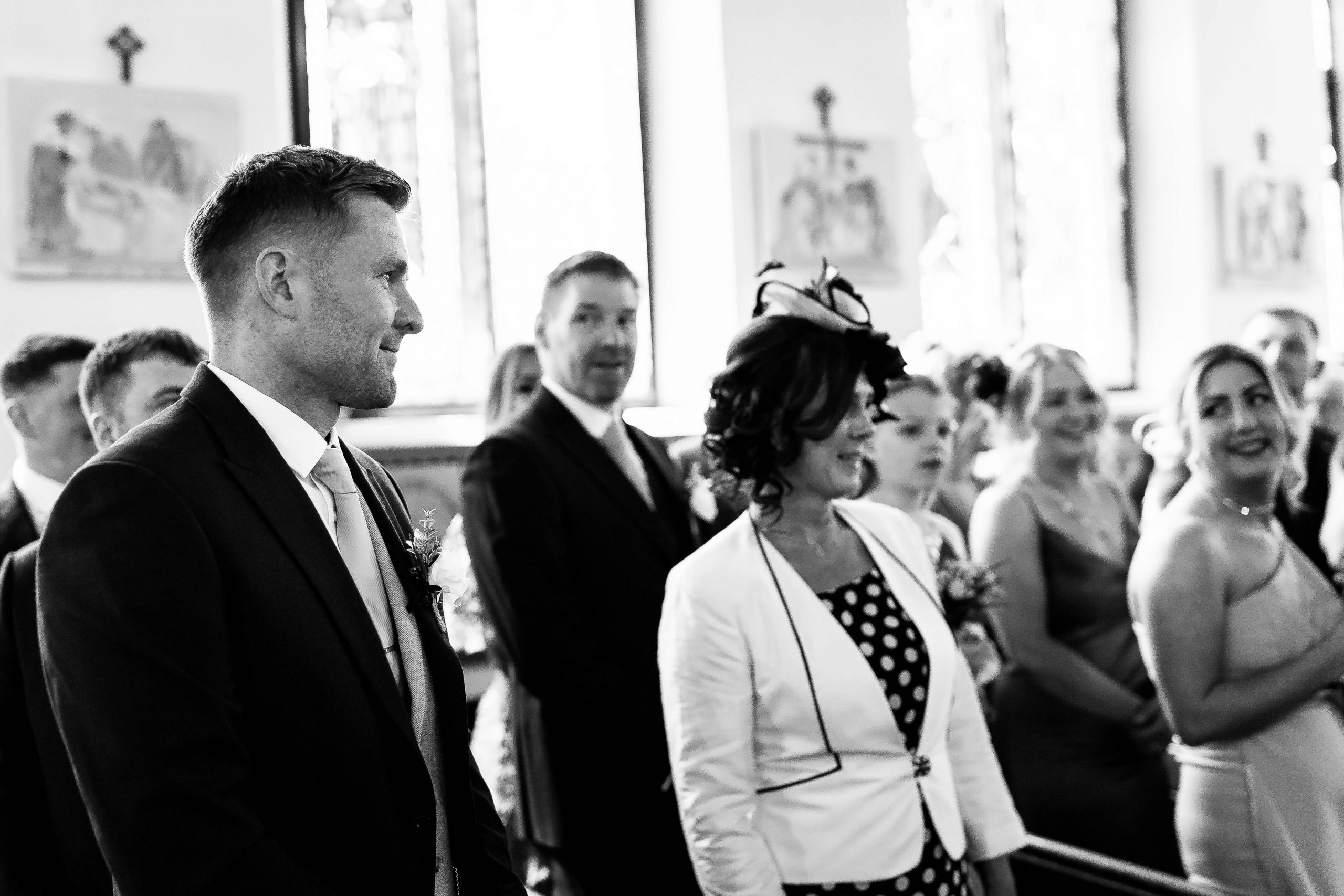 Groom smiles as he watches the bride walks up the aisle