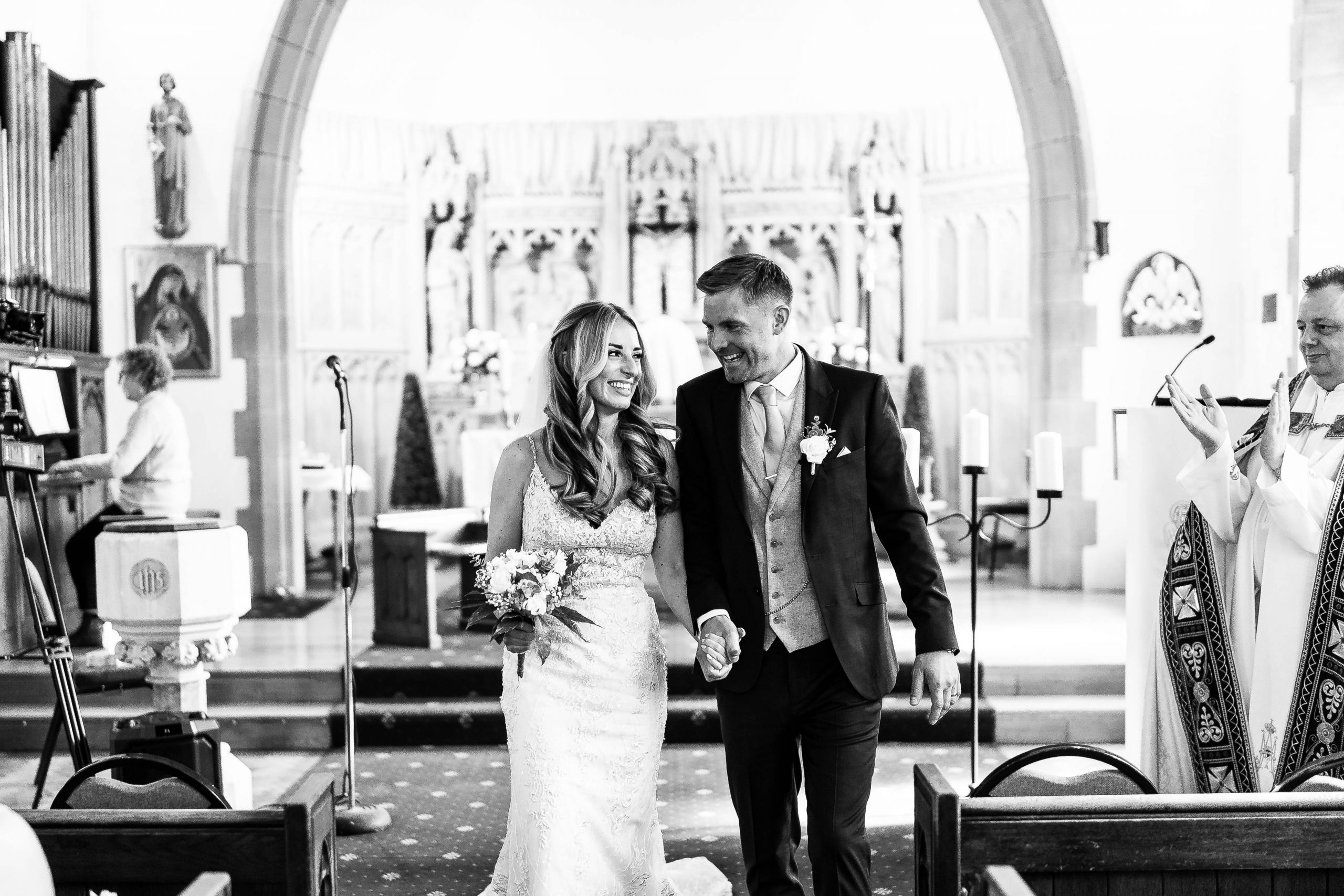 Bride and groom laugh together as they walk back down the aisle