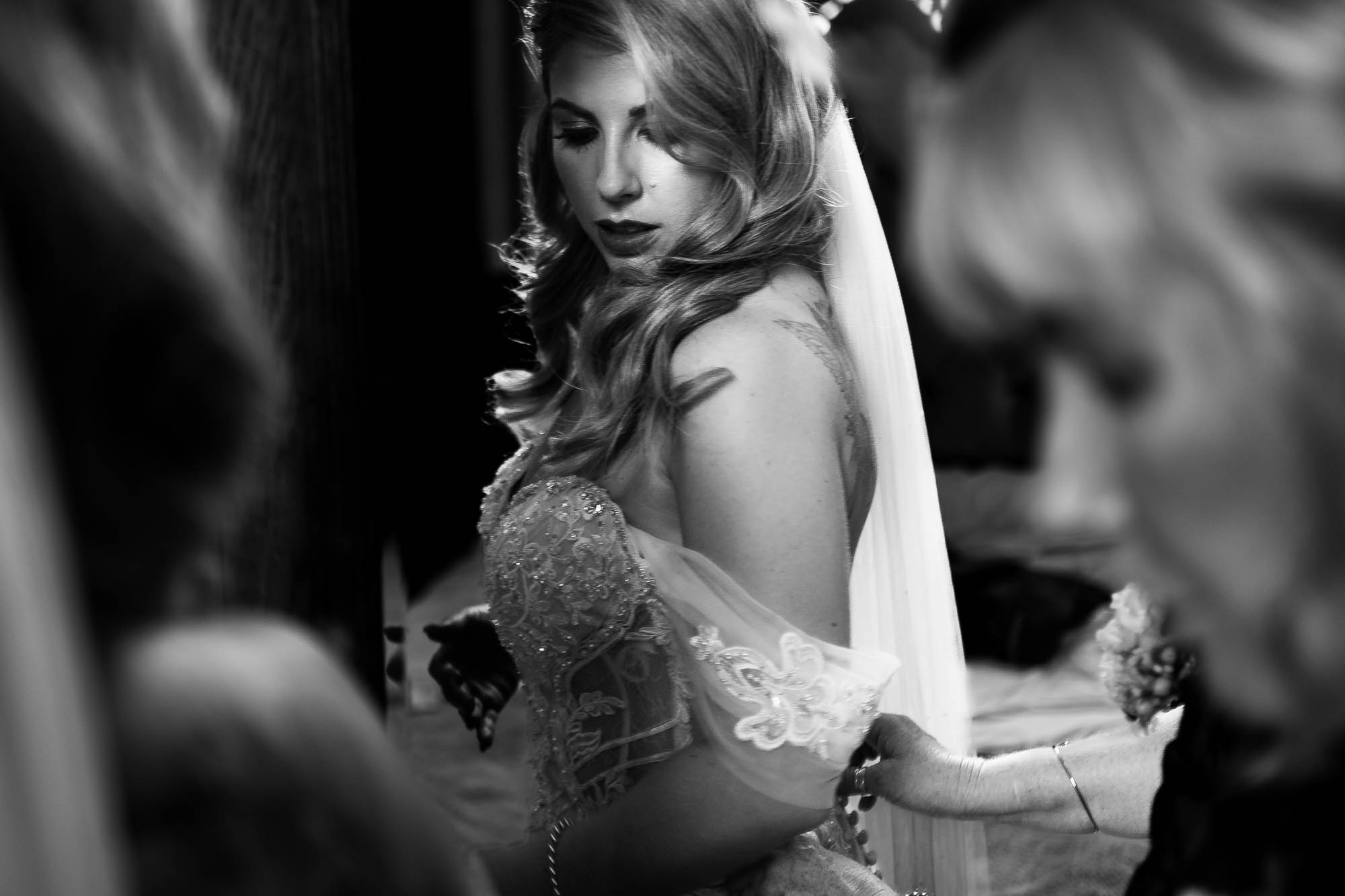 Bride having her dress adjusted 