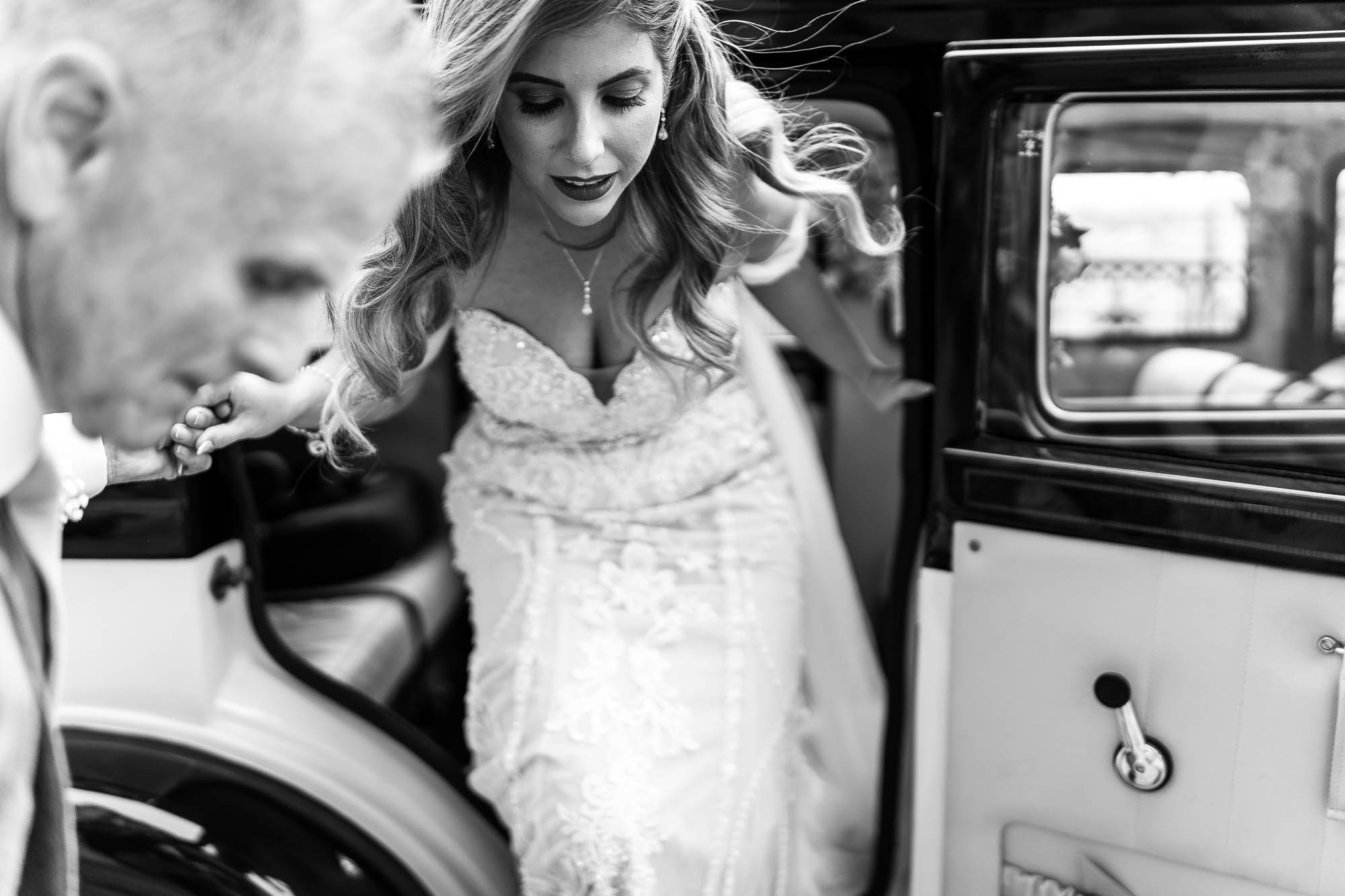 Bride gets out of wedding car