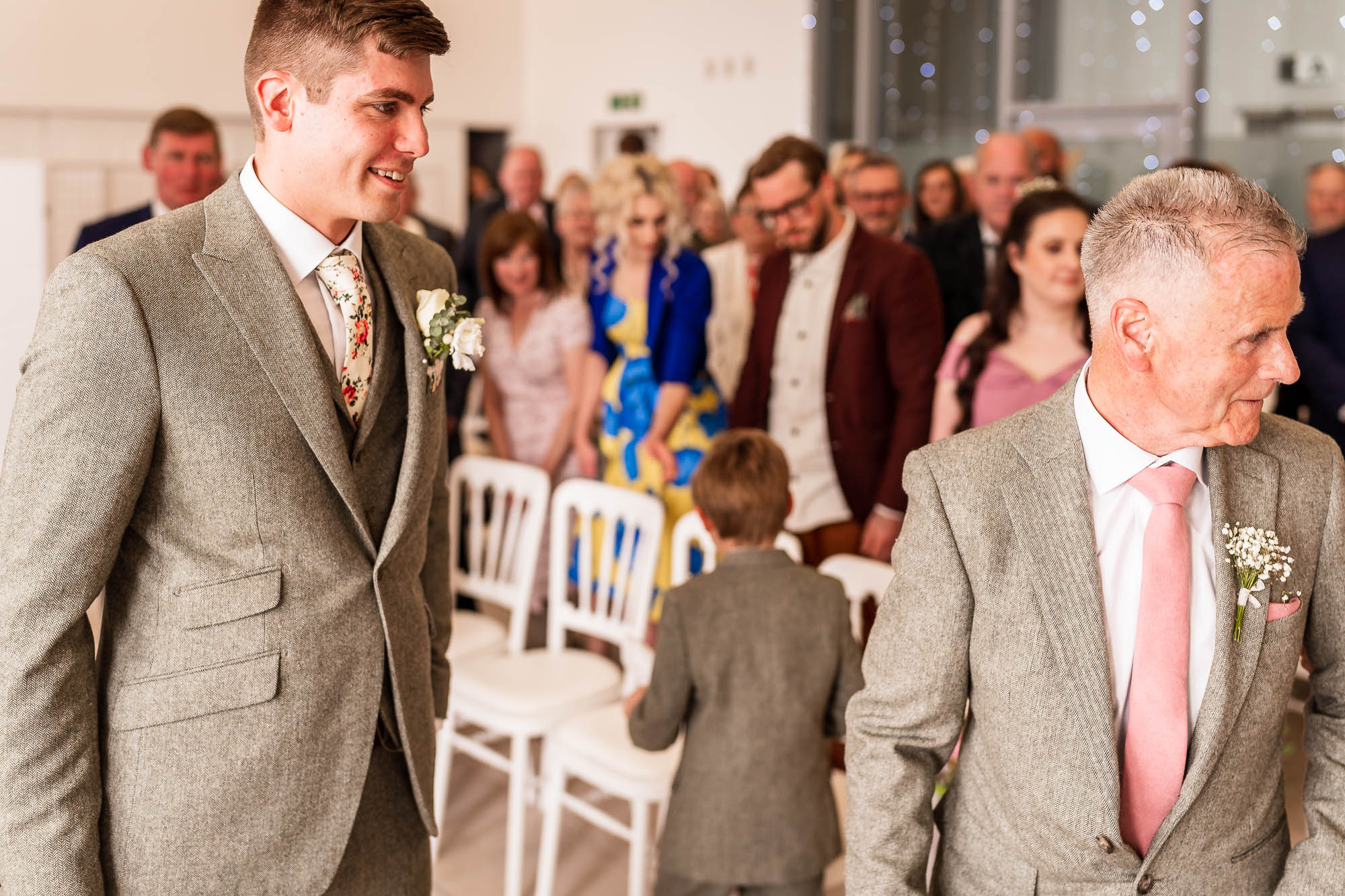Groom smiles at the bride as she arrives 