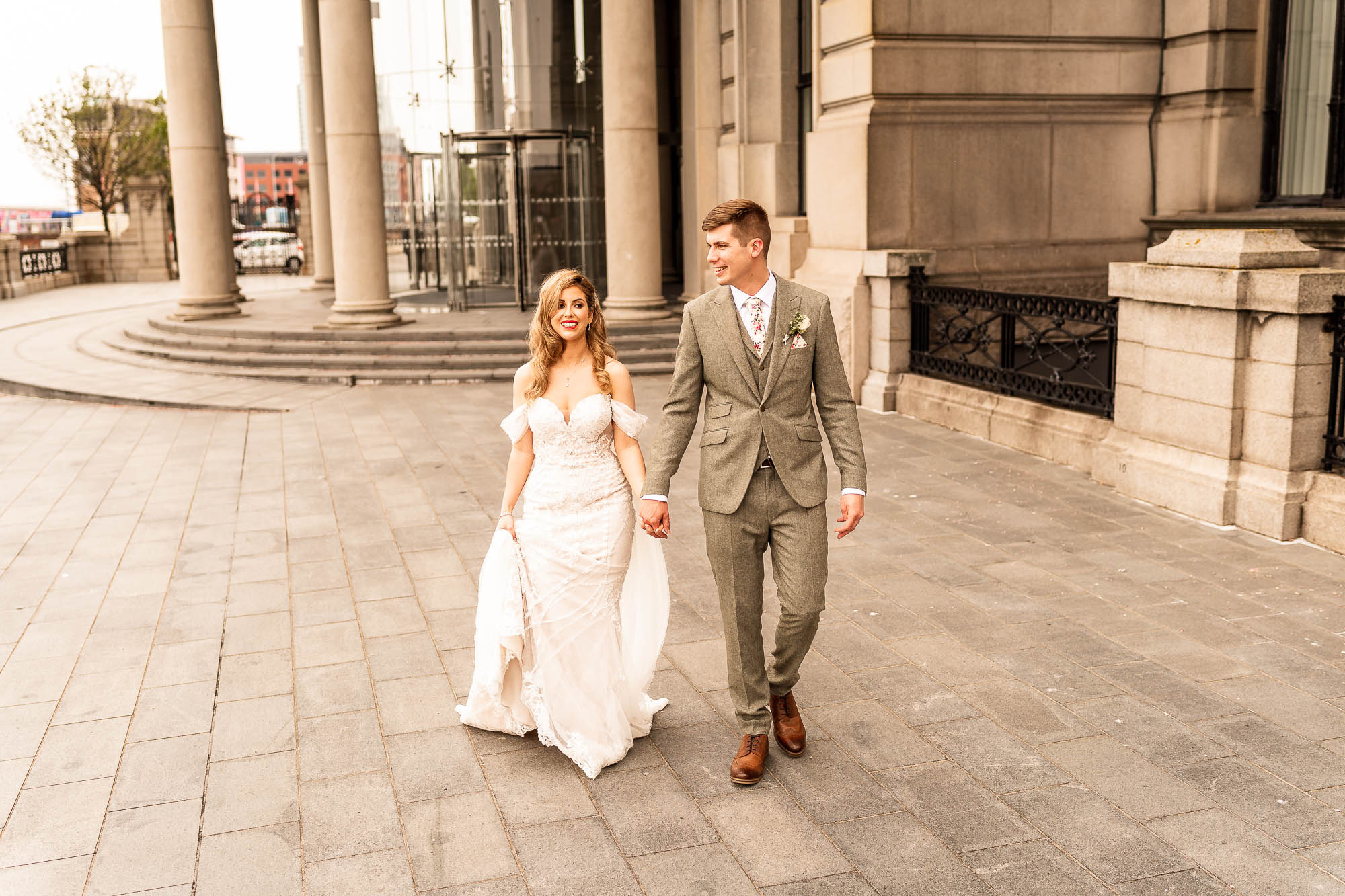 Bride and groom walk out of Liver building