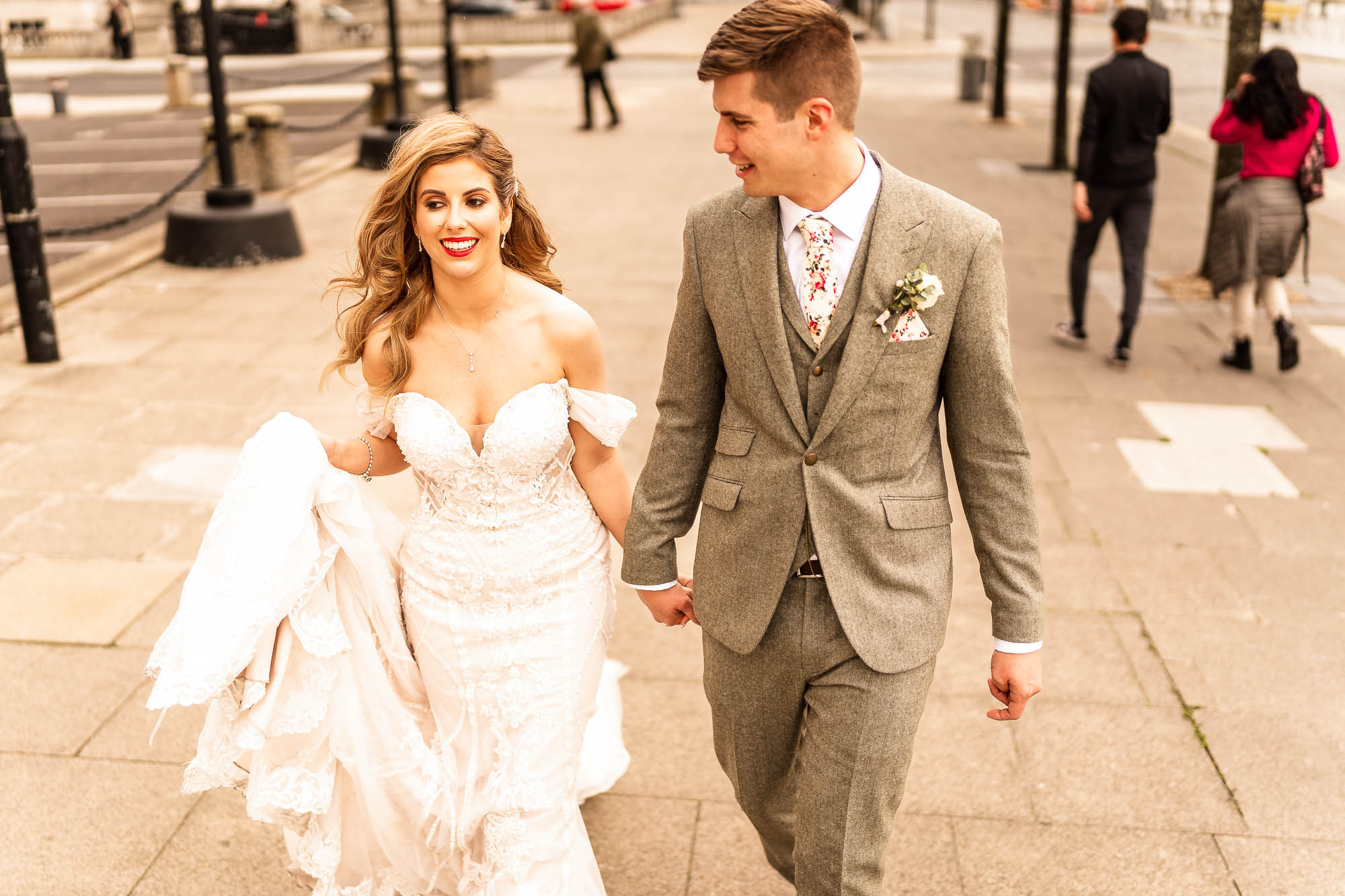 Bride and groom walk back to the Liver building