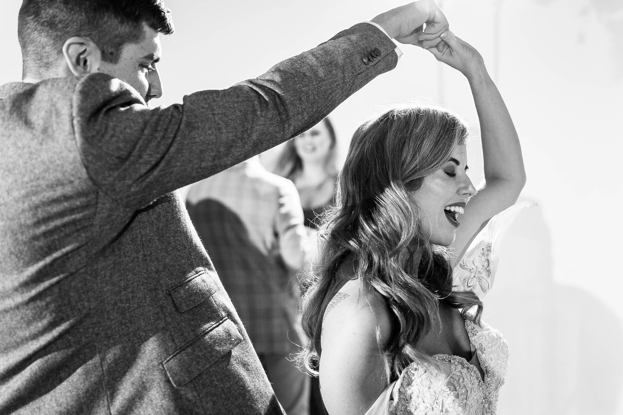 Groom twirling bride on dancefloor
