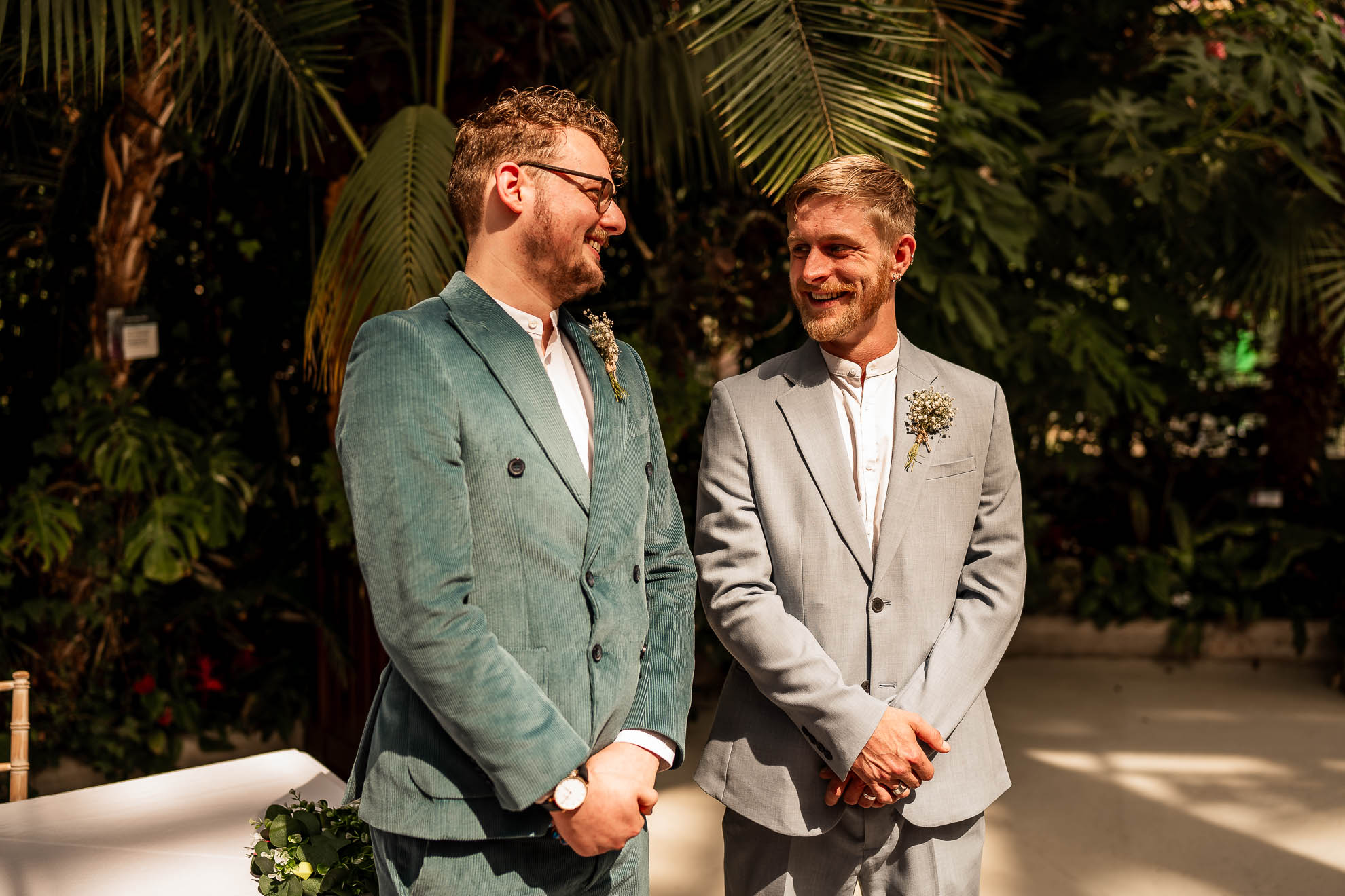 Groom and best man share a joke while waiting for the bride