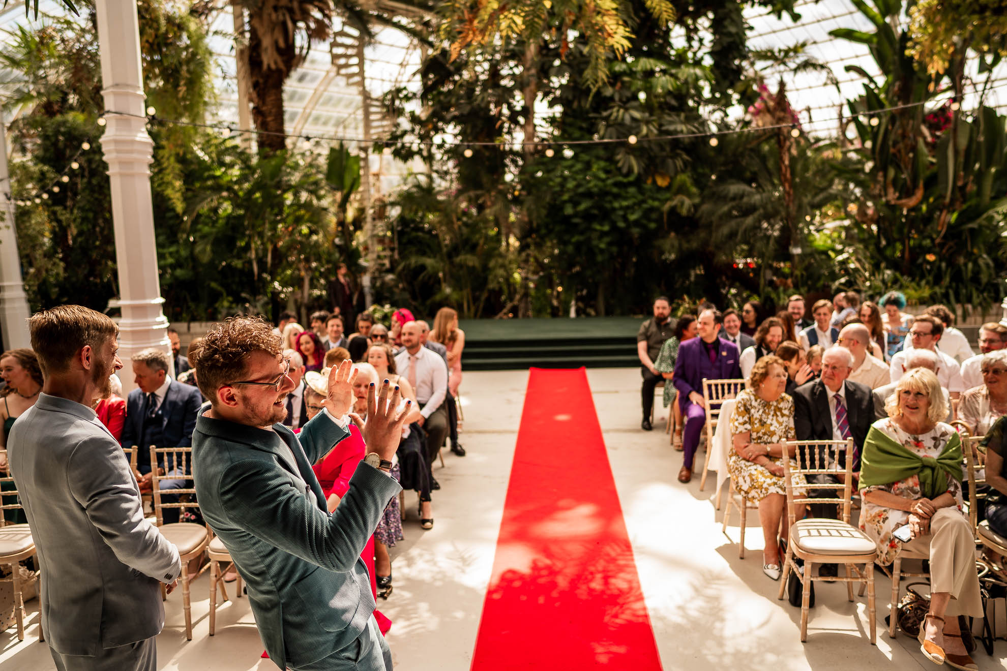 Groom messing about waiting at the top of the aisle