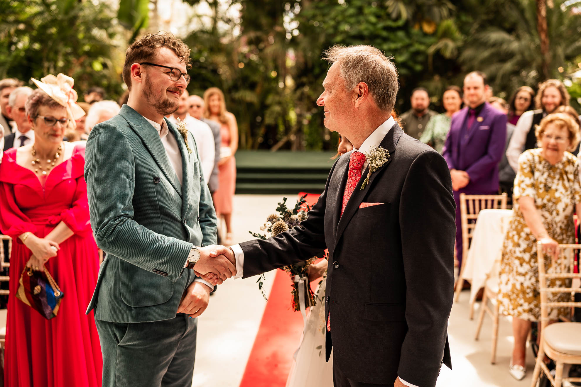 Father of the bride and groom shake hands