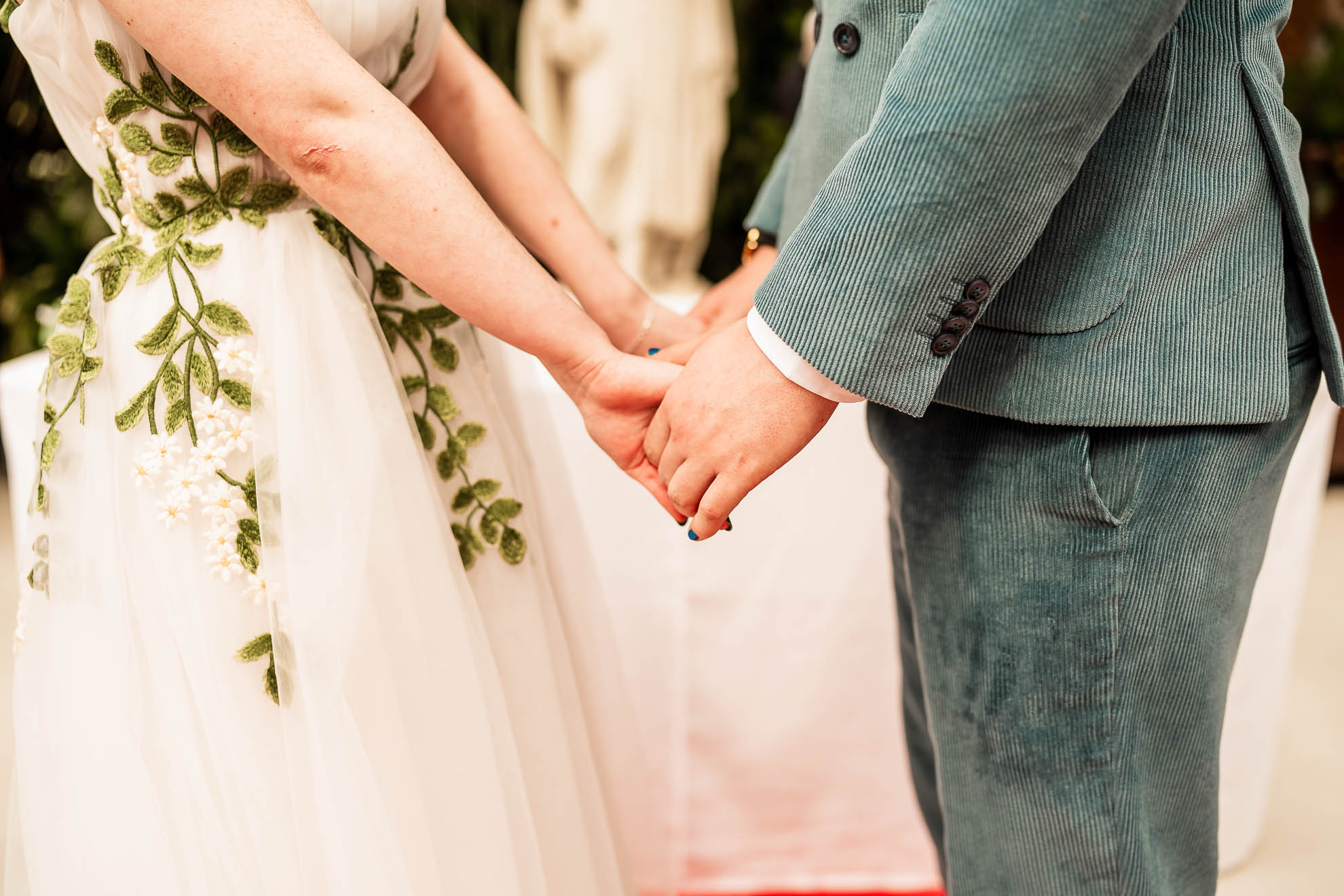 close up of bride and groom holding hands