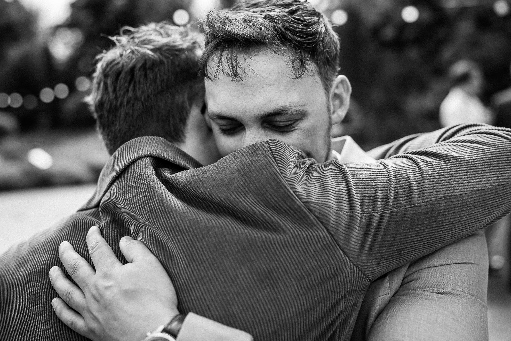 Groomsmen gives groom a hug