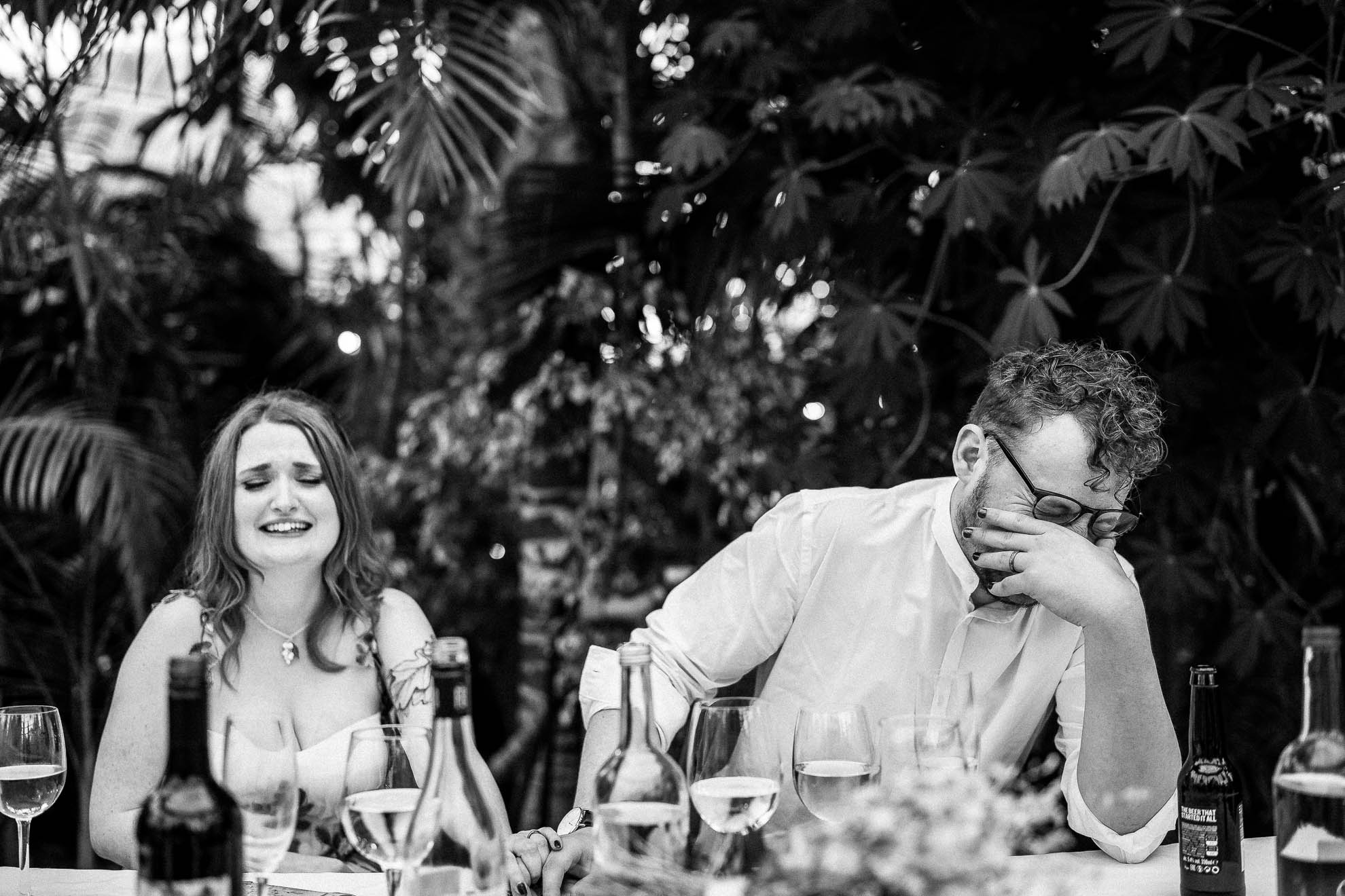 Bride and groom laughing at best mans speech
