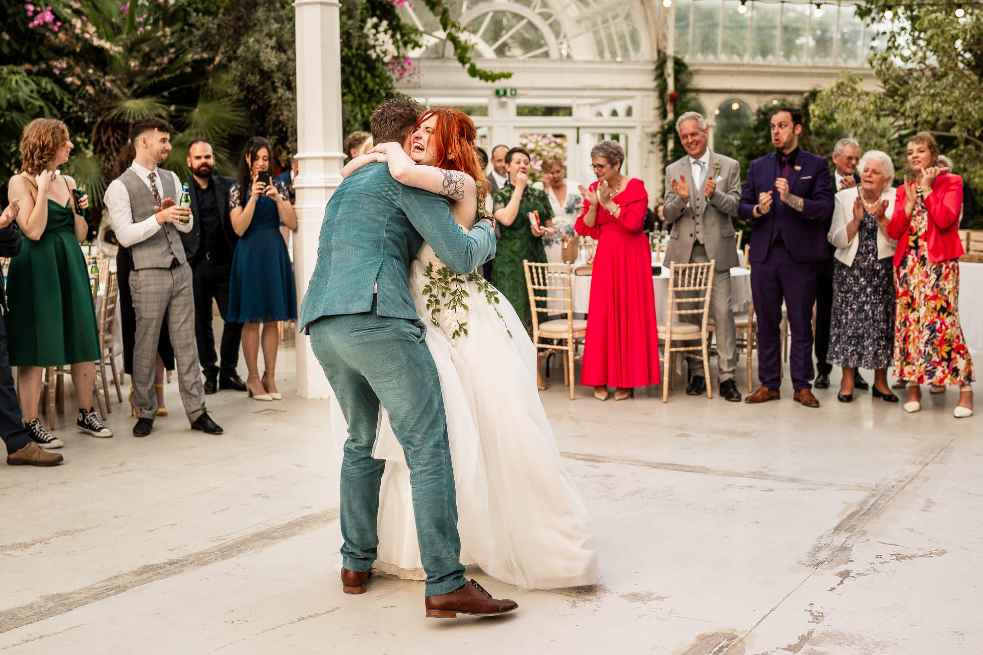 Long shot of bride and groom first dance with guest surrounding them