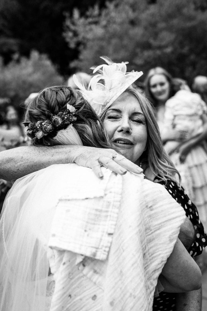 mother of the groom gives bride a hug