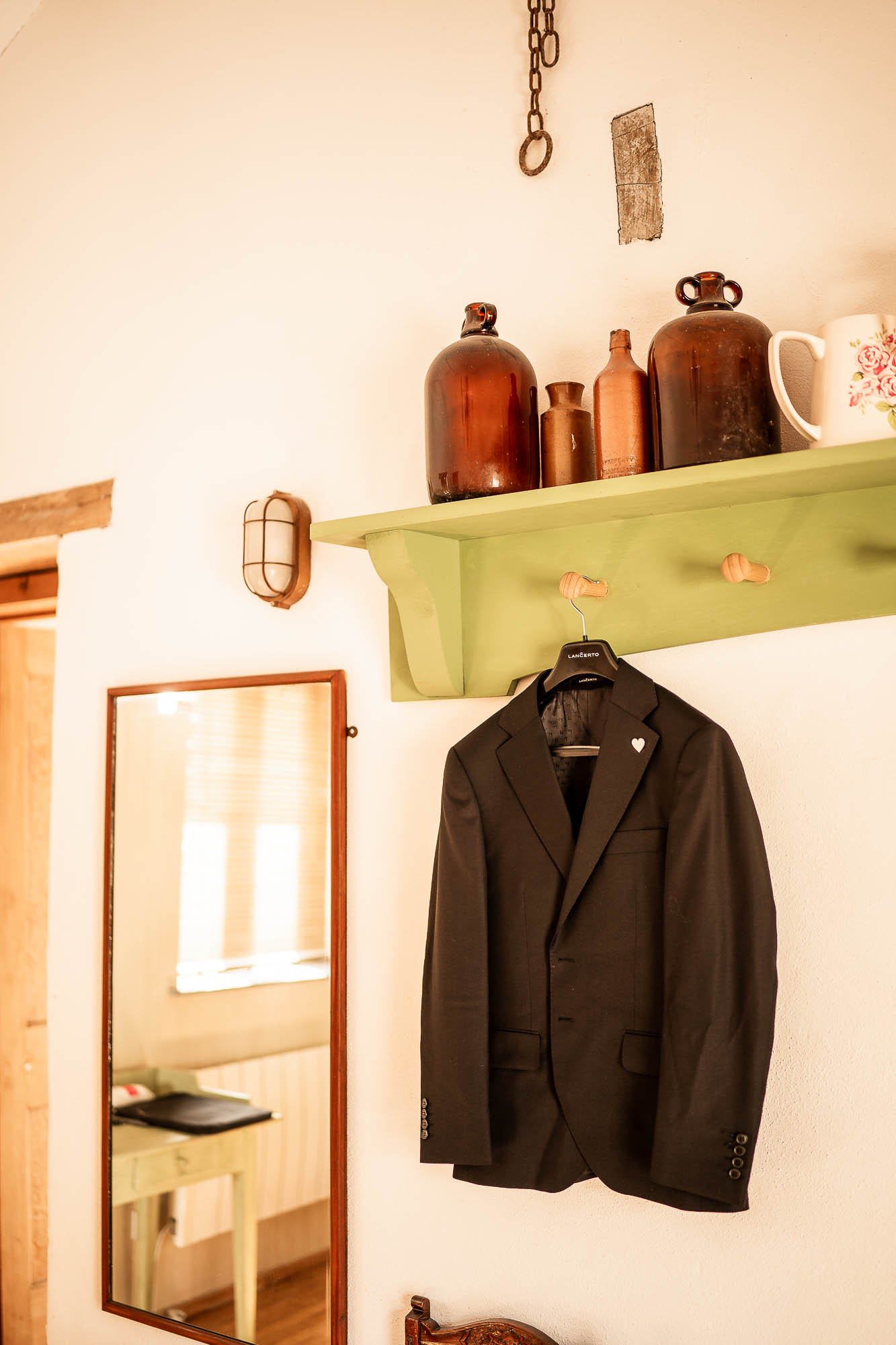 Groom’s suit hanging on rustic wall at Wonwood Barton