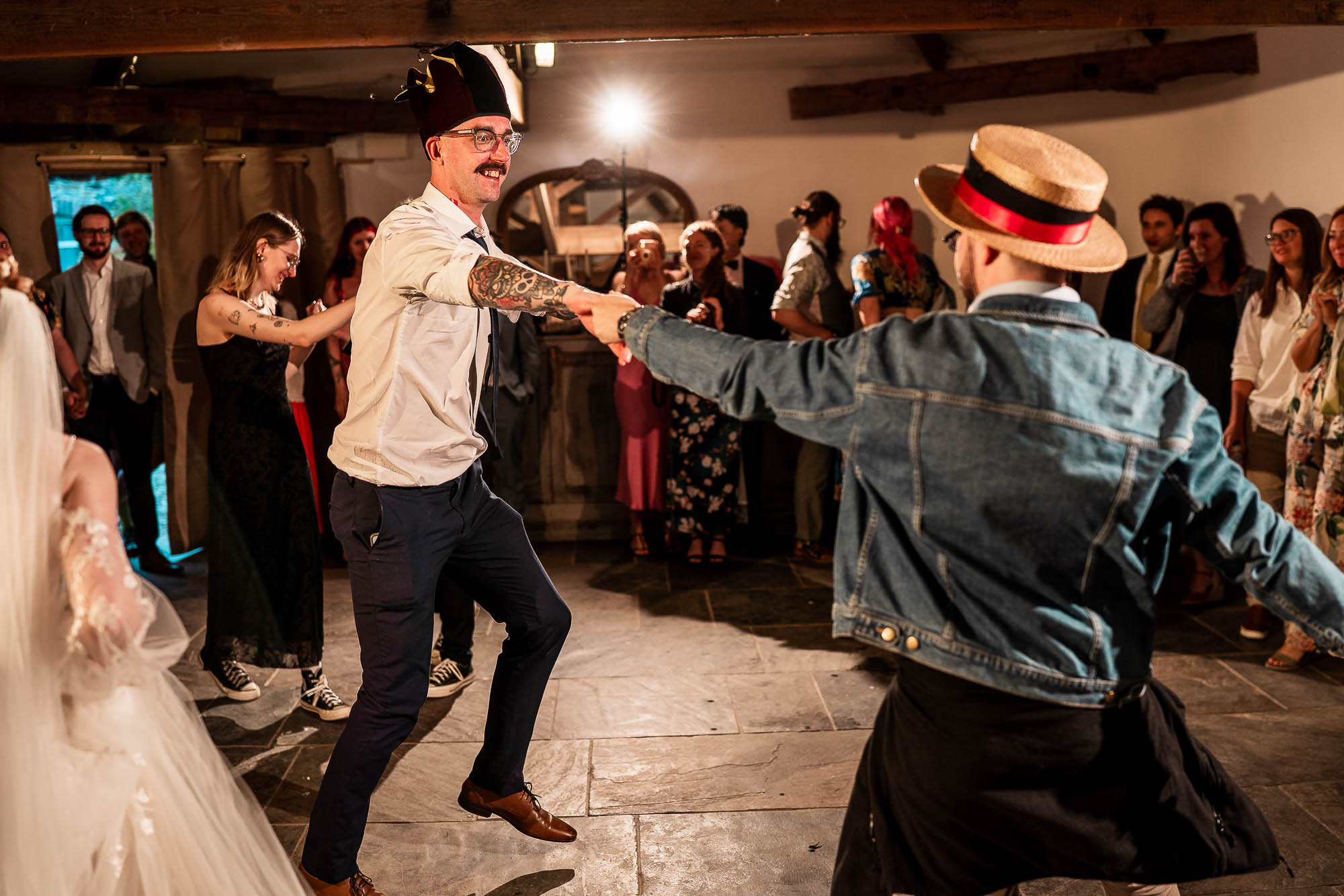 Wedding guests dancing in circle during evening reception at Devon barn wedding