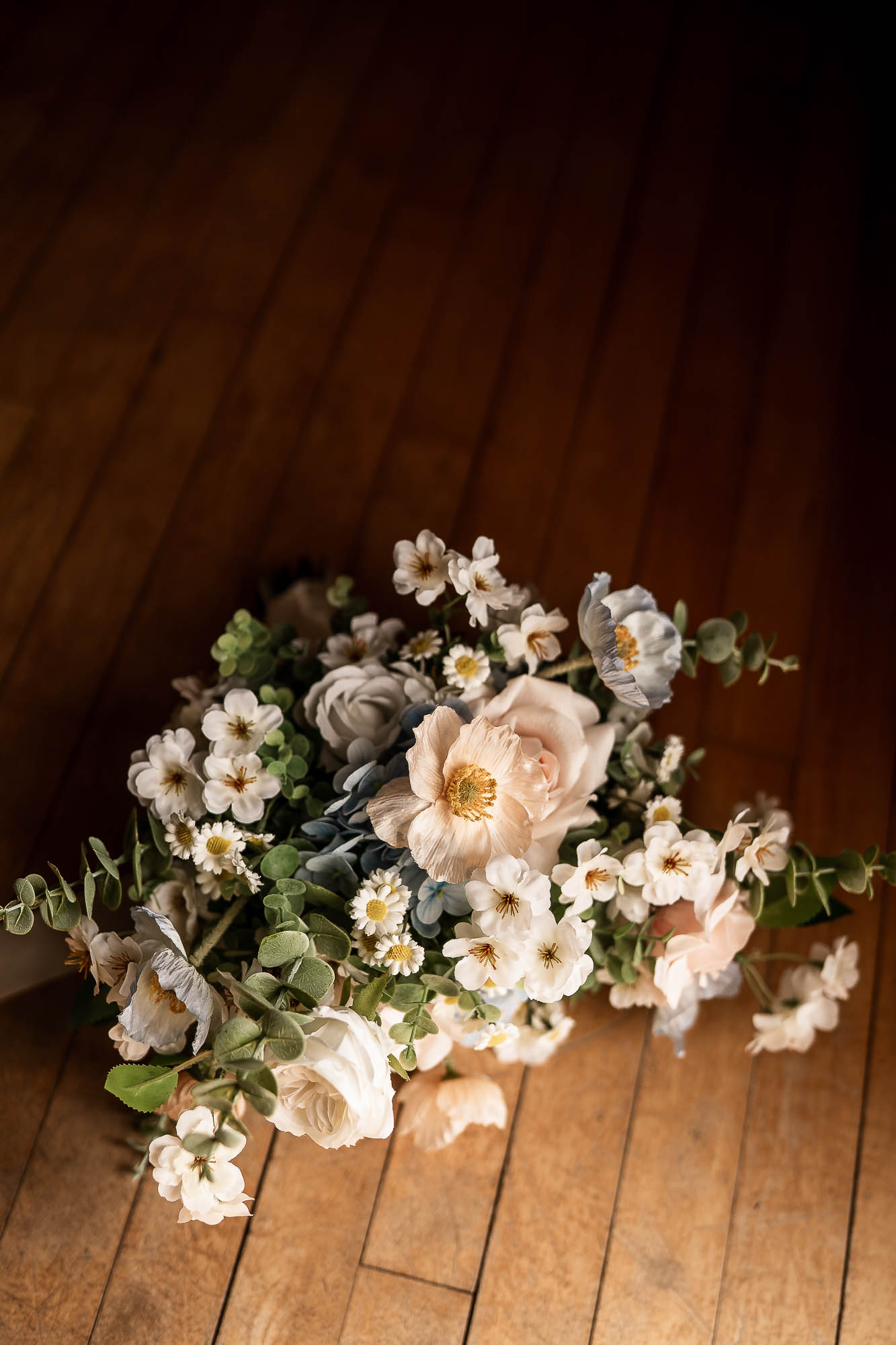 Wedding bouquet with soft pastel flowers on wooden floor