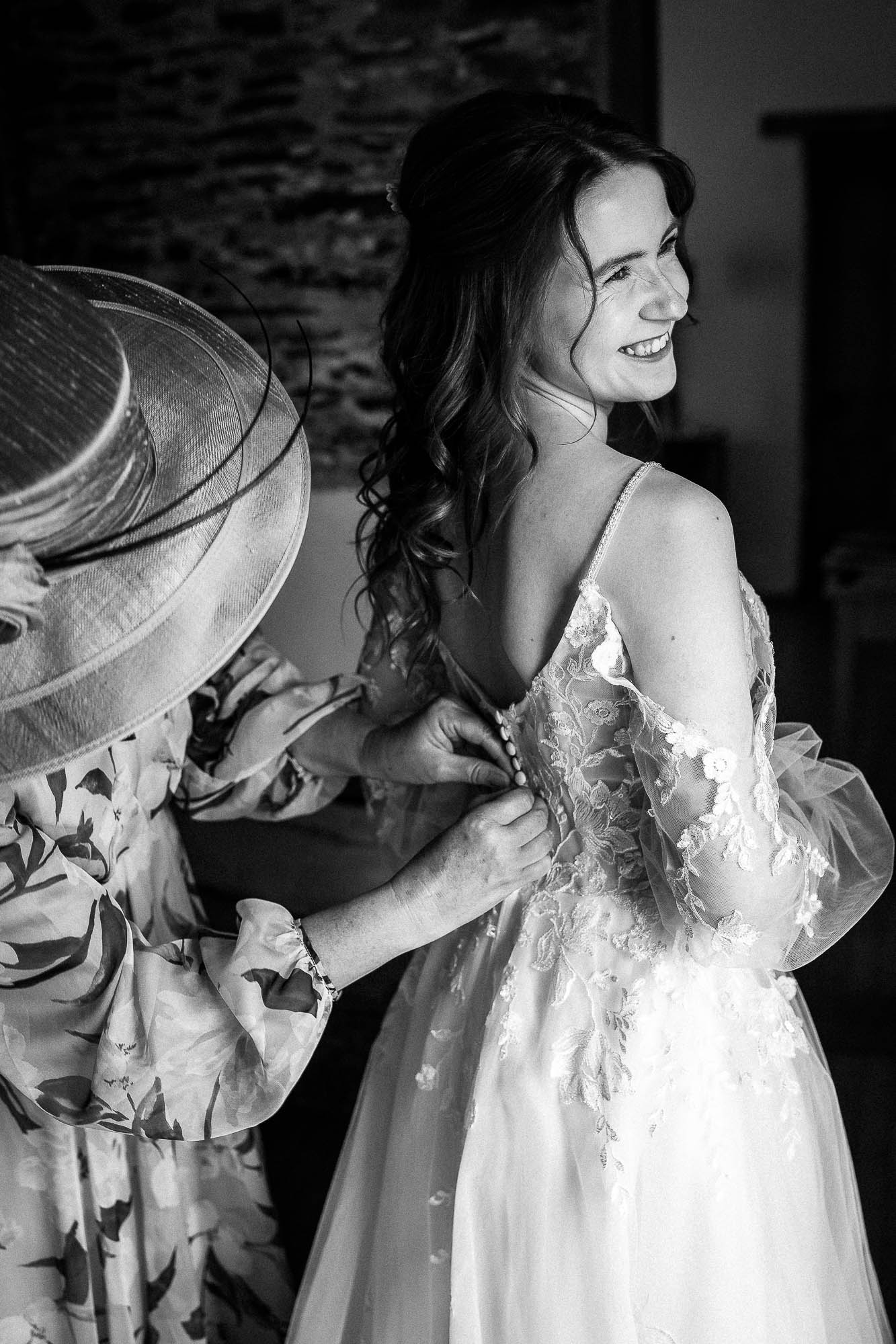 Close-up of bride’s hands resting on detailed lace bodice during bridal prep at Wonwood Barton wedding