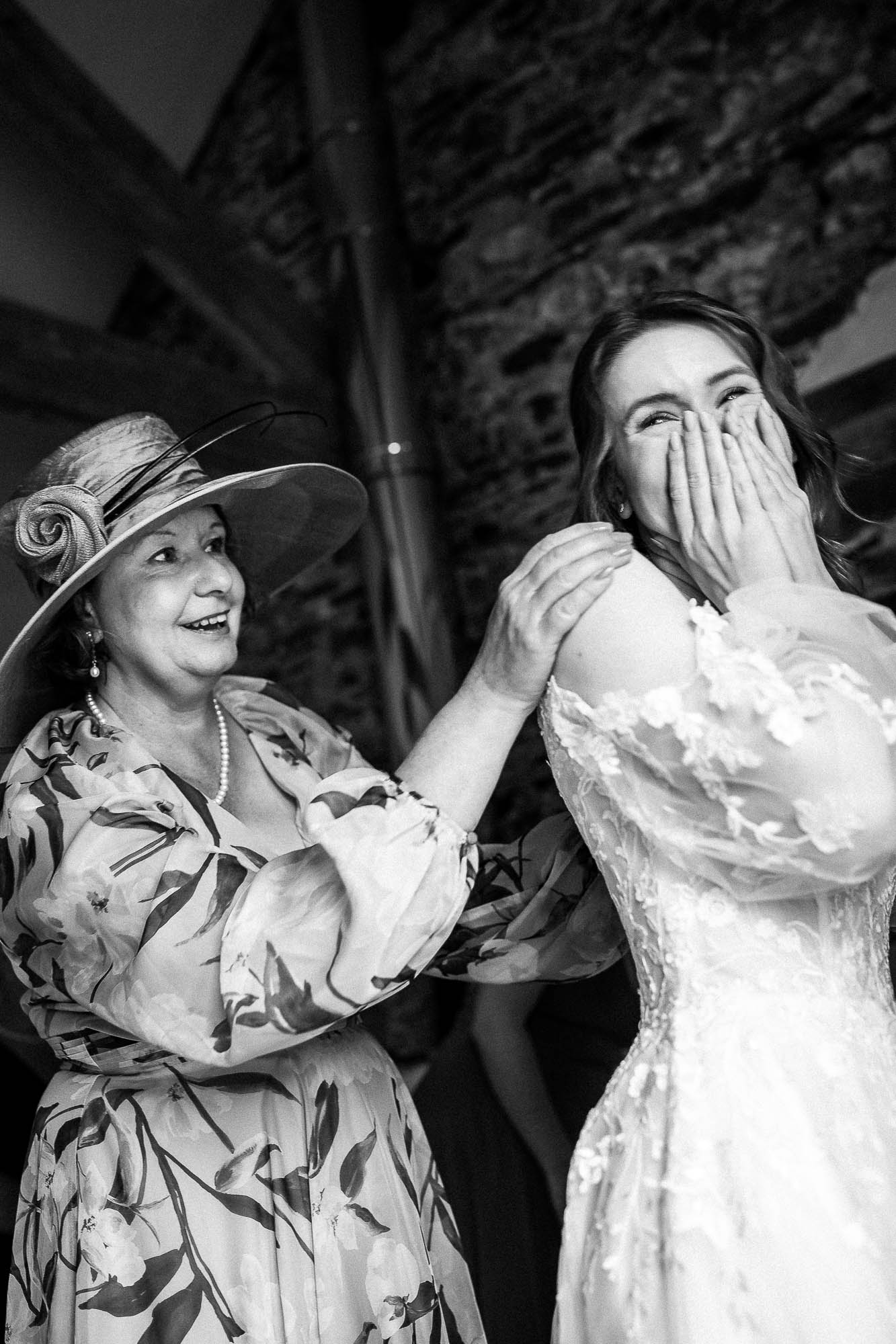 Emotional bride reacting as smother of the bride adjusts dress during Wonwood Barton bridal preparations